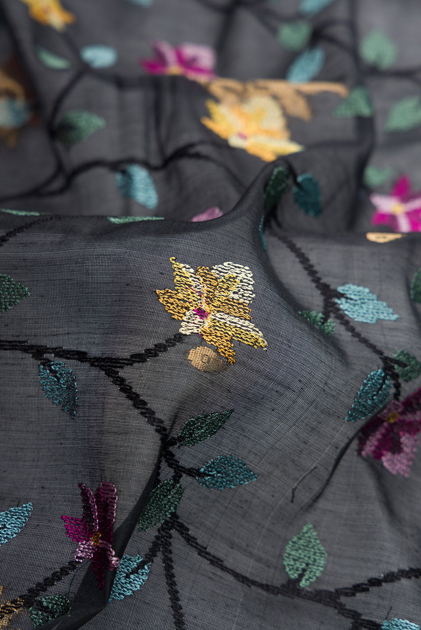 Close up of Black Dual Tone Tussar Silk Saree with Embroidery on the body and Zari Border.  displaying folds