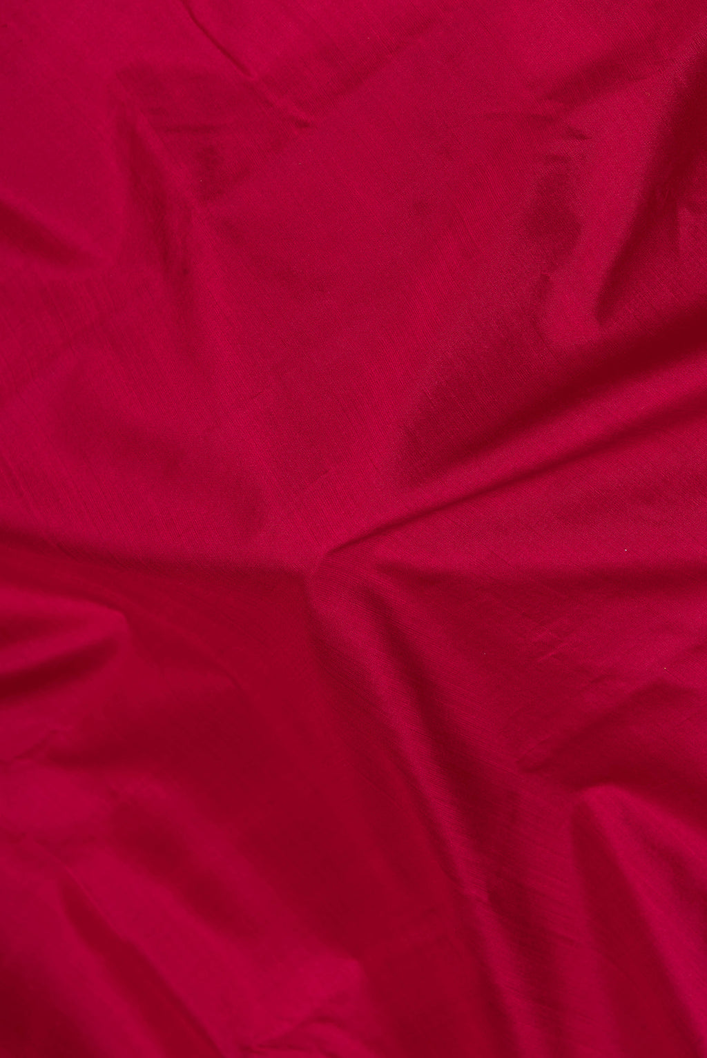 Close up of Maroon Kanjivaram Silk Saree with Plain Body and Zari Border.  displaying folds