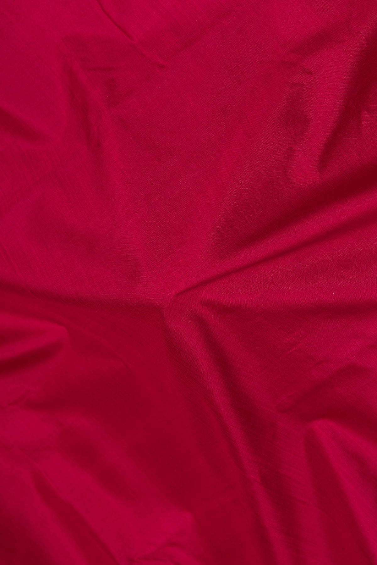 Close up of Maroon Kanjivaram Silk Saree with Plain Body and Zari Border.  displaying folds