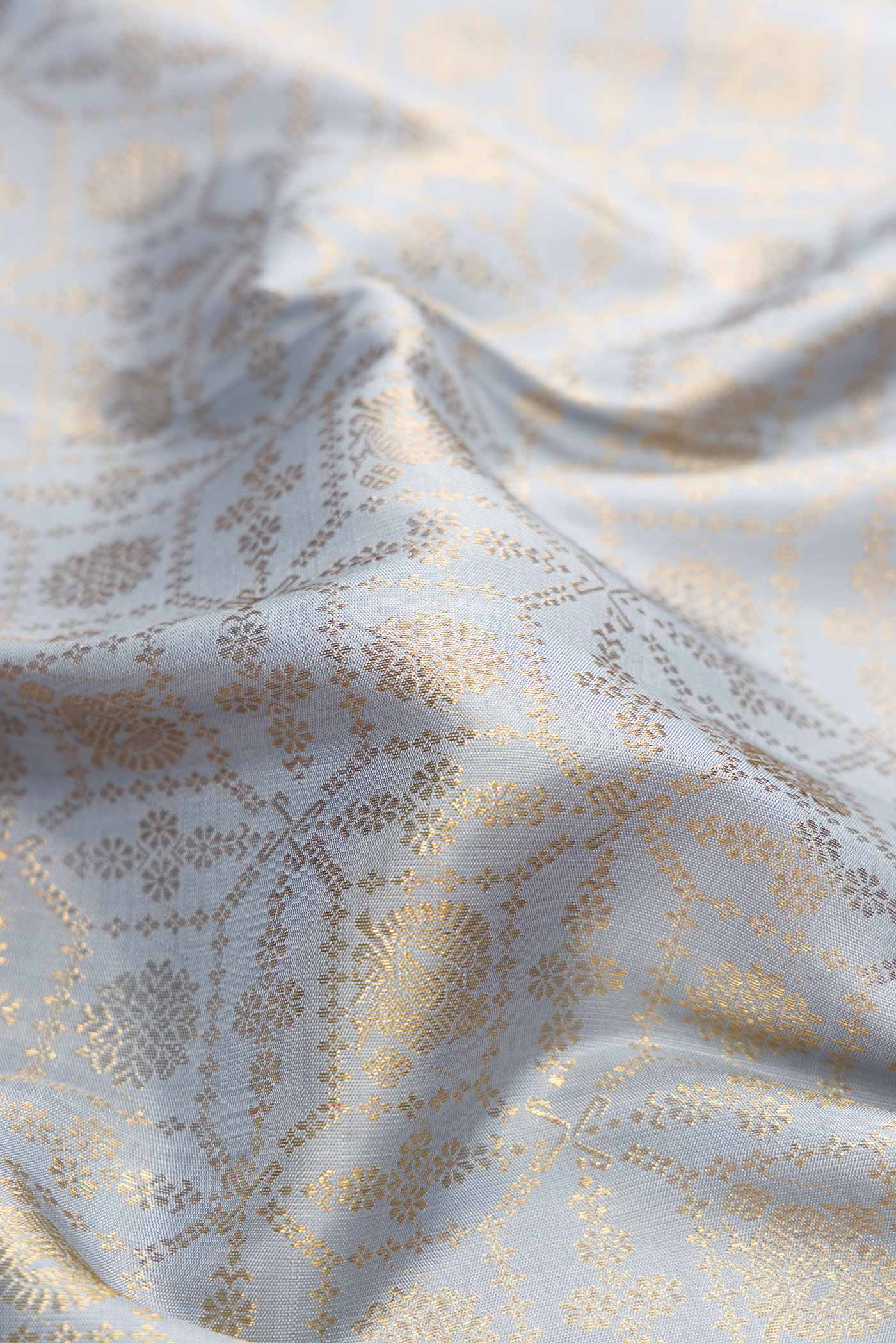 Close up of Grey Dual Tone Kanchipuram Silk Saree with Zari Brocade on the body and Zari Border.  displaying folds