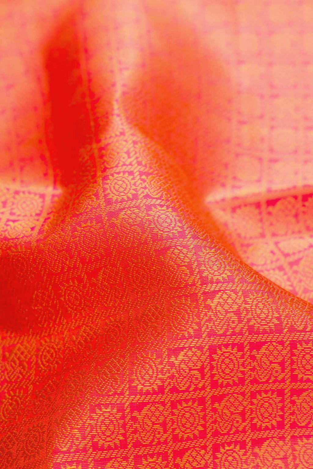 Close up of Pure Silk Pure Zari Orange Dual Tone Kanjivaram Saree with Jacquard design on the body and Thin Zari Line.  displaying folds