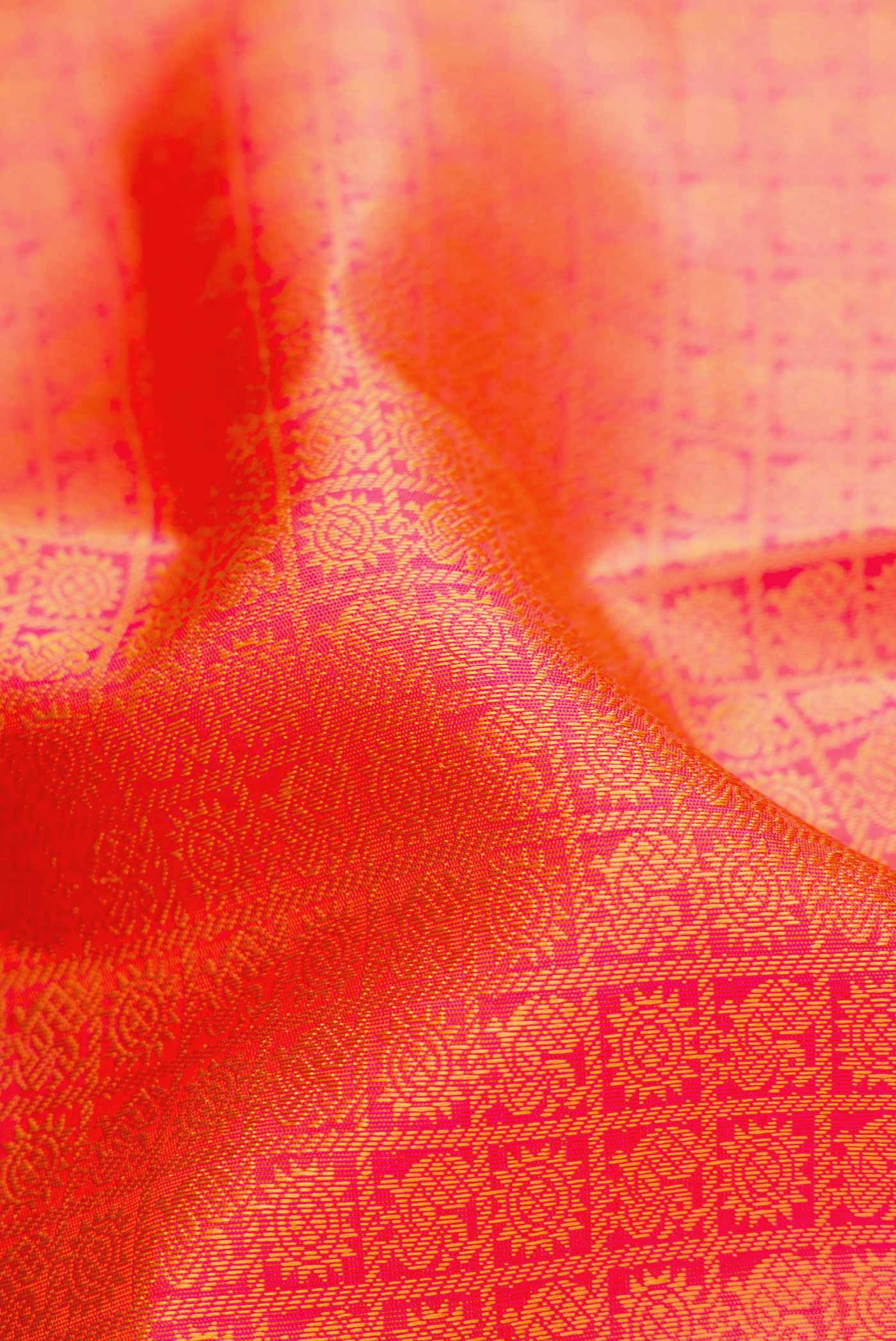 Close up of Pure Silk Pure Zari Orange Dual Tone Kanjivaram Saree with Jacquard design on the body and Thin Zari Line.  displaying folds