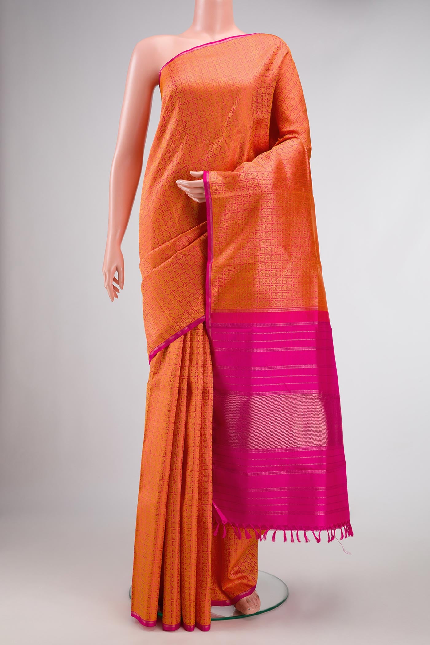 Pure Silk Pure Zari Orange Dual Tone Kanjivaram Saree with Jacquard design on the body and Thin Zari Line.  displayed on a mannequin