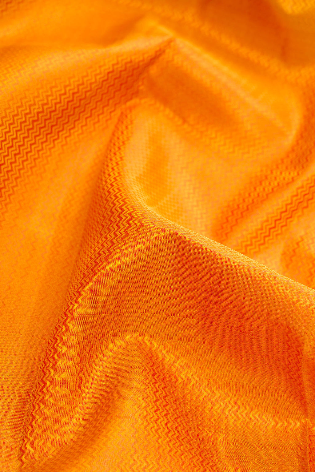 Close up of Pure Silk Pure Zari Mustard Dual Tone Kanchipuram Saree with Jacquard design on the body and Zari And Thread Border.  displaying folds