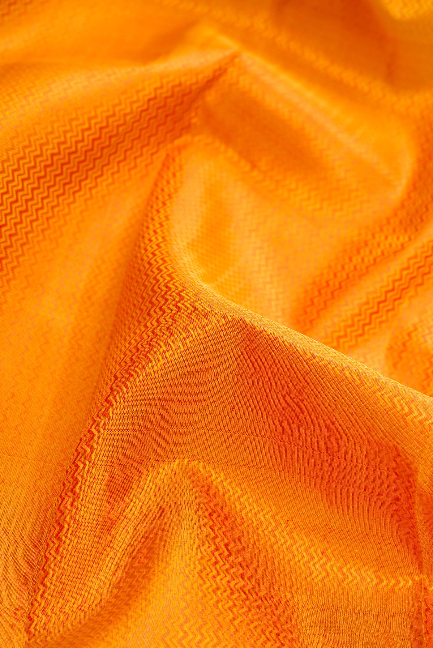 Close up of Pure Silk Pure Zari Mustard Dual Tone Kanchipuram Saree with Jacquard design on the body and Zari And Thread Border.  displaying folds