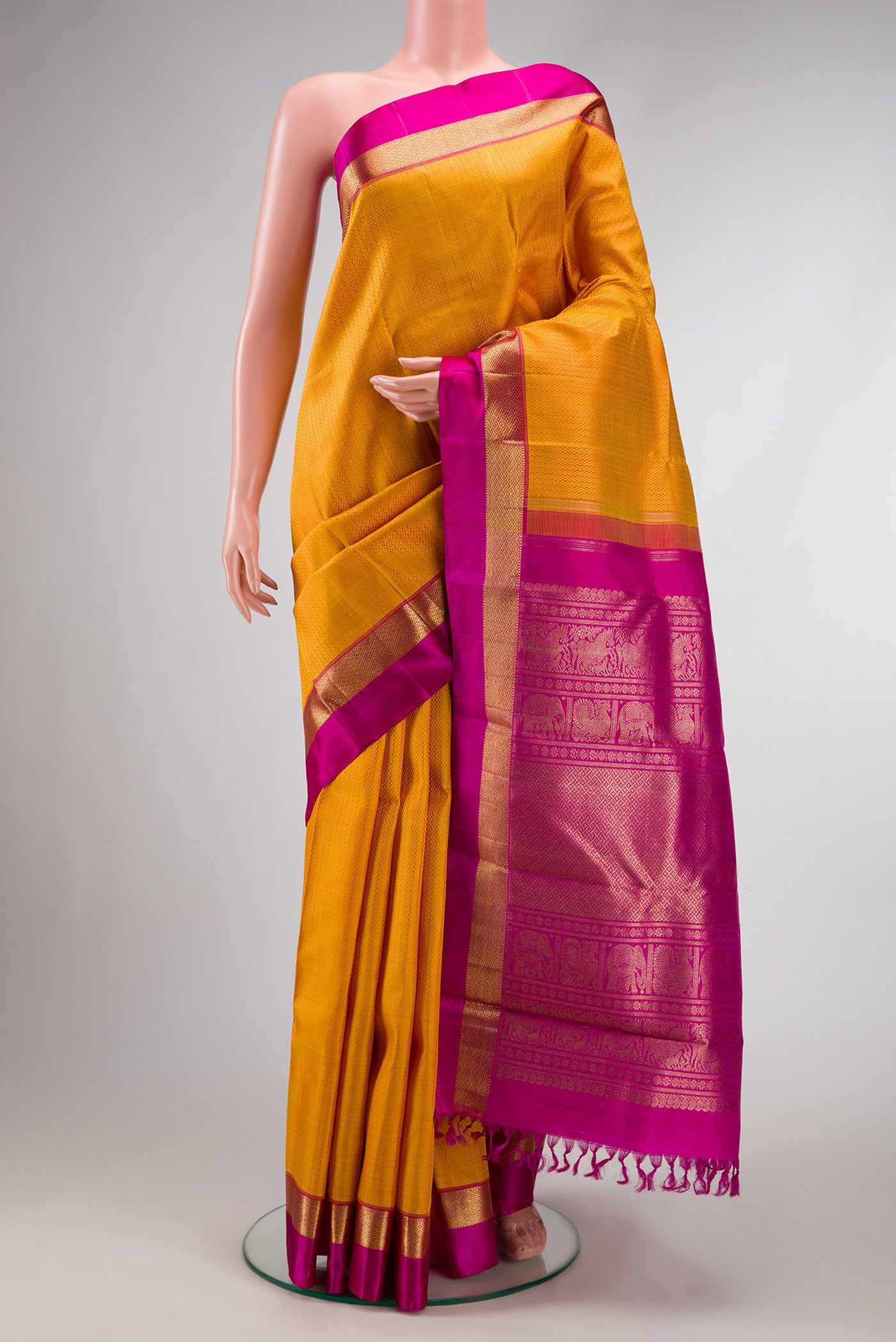 Pure Silk Pure Zari Mustard Dual Tone Kanchipuram Saree with Jacquard design on the body and Zari And Thread Border.  displayed on a mannequin