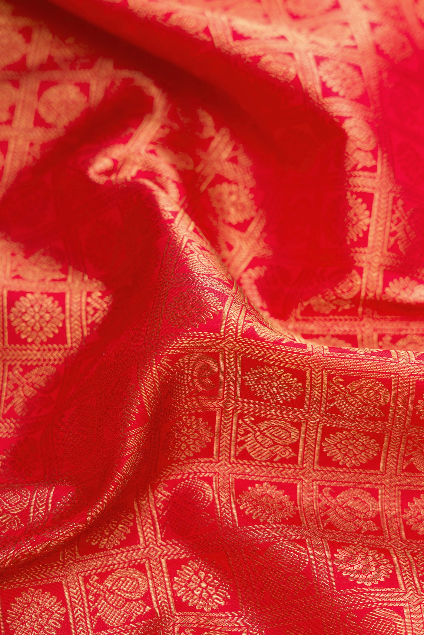Close up of Pure Silk Pure Zari Red Dual Tone Kanjivaram Saree with Zari Brocade on the body and Zari Border.  displaying folds