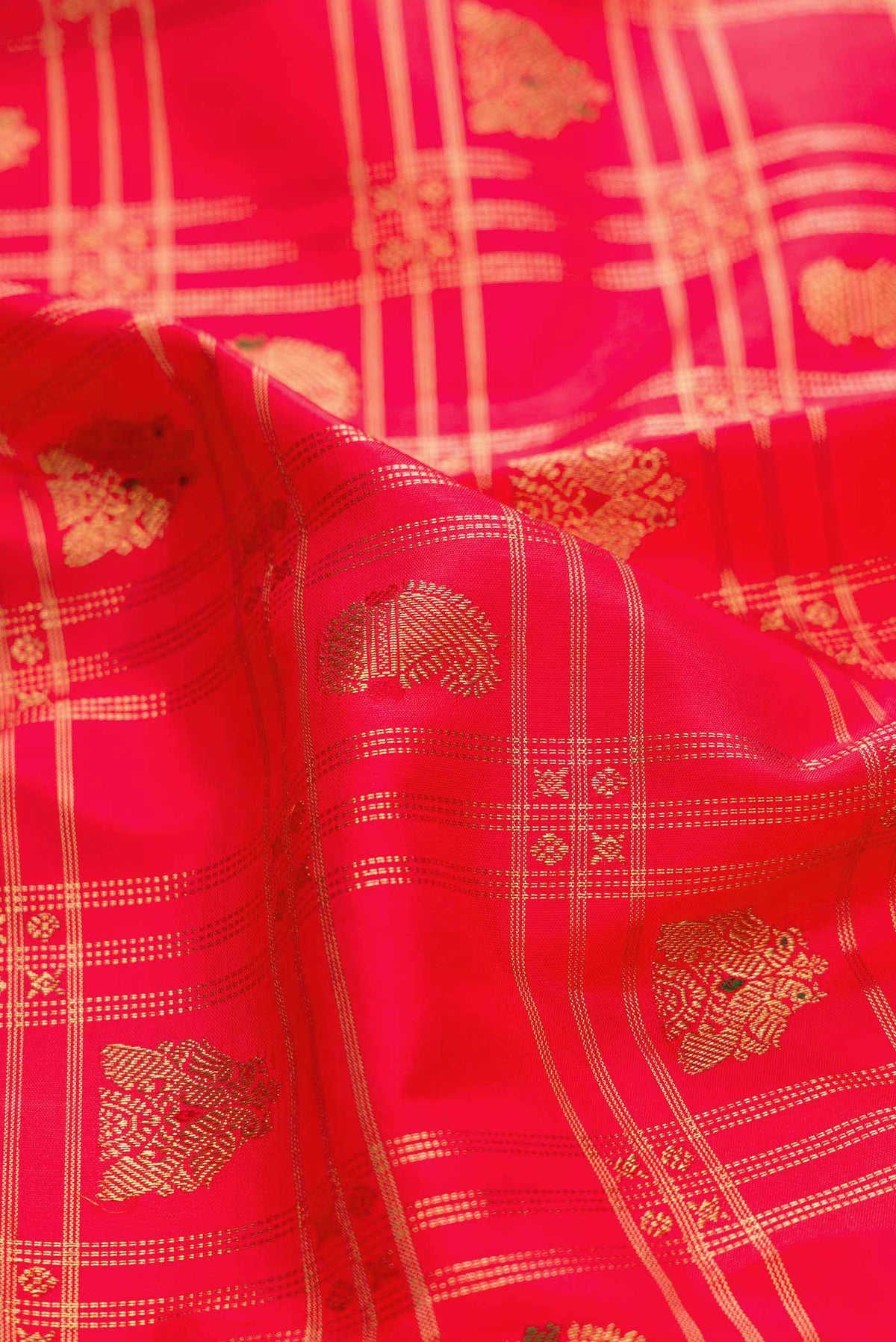 Close up of Red Dual Tone Kanchipuram Silk Saree with Checked design on the body and Zari Border displaying folds