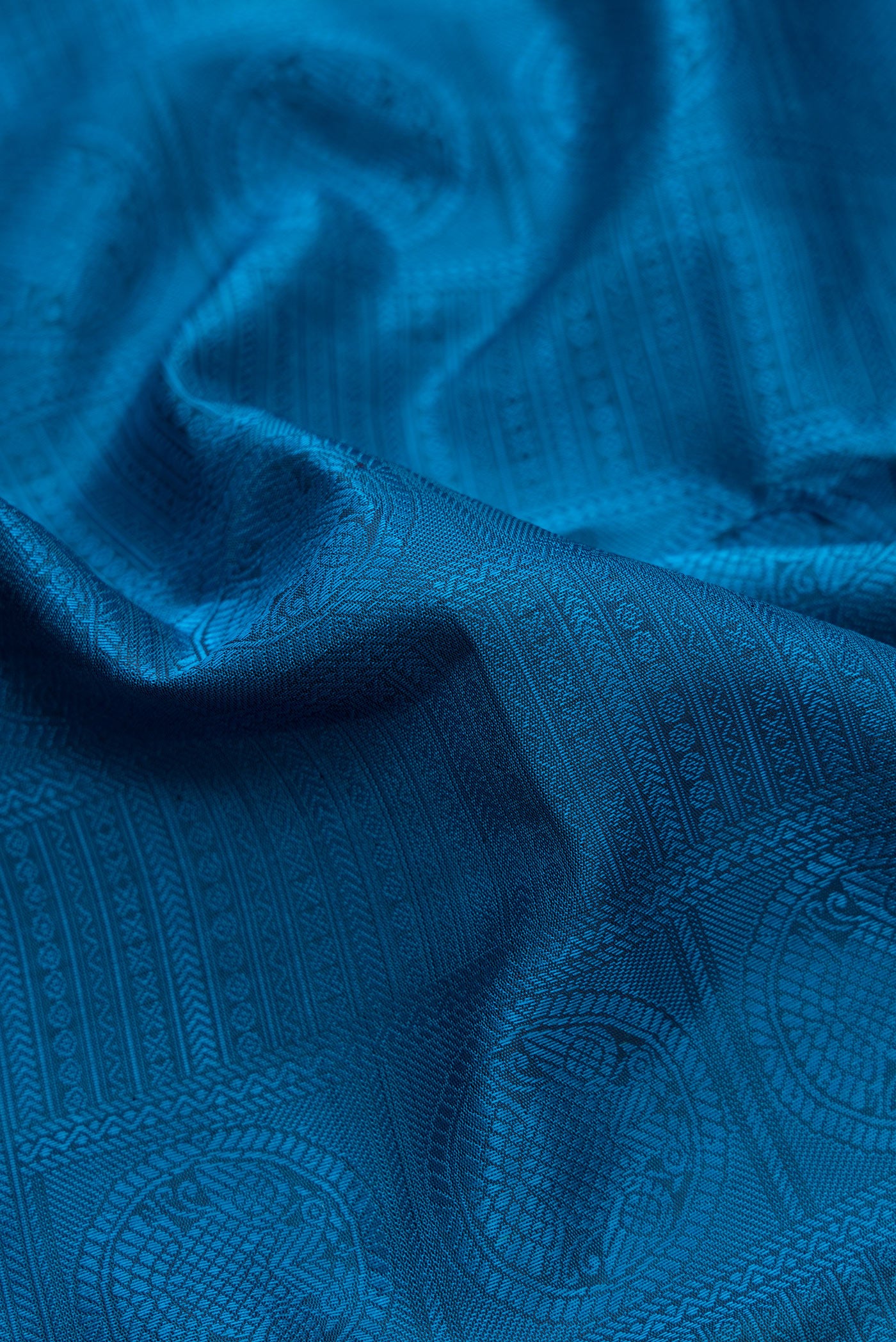 Close up of Pure Silk Pure Zari Peacock Blue Dual Tone Kanchipuram Saree with Jacquard design on the body and Checks Border.  displaying folds