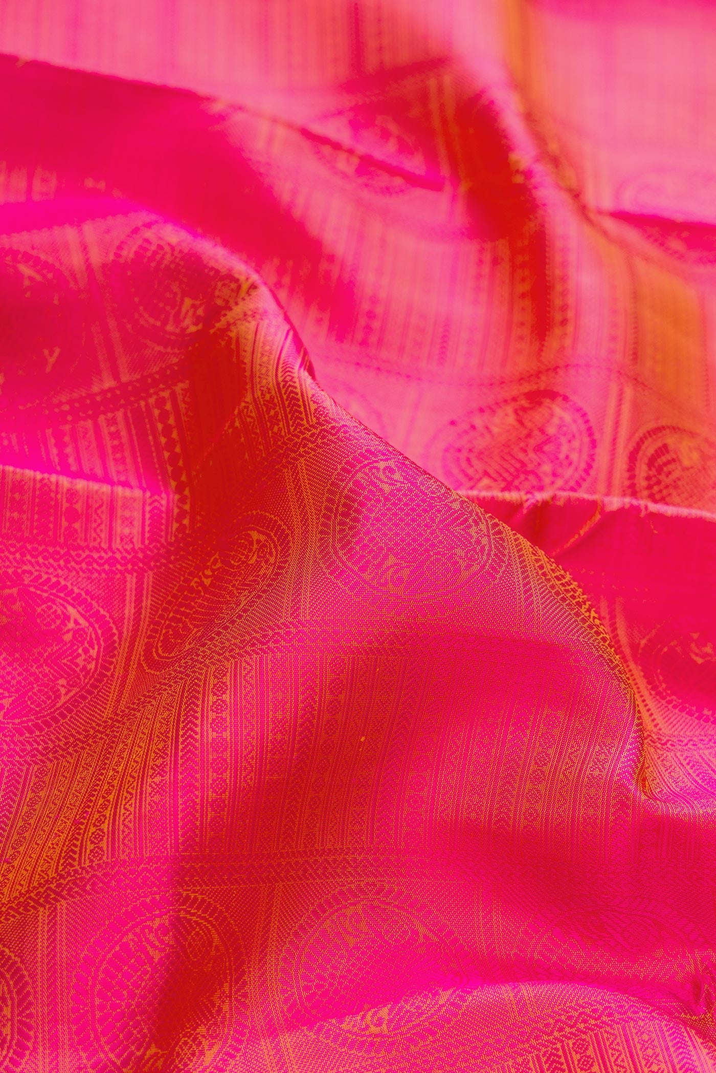 Close up of Pure Silk Pure Zari Coral Dual Tone Kanchipuram Saree with Jacquard design on the body and Checks Border.  displaying folds