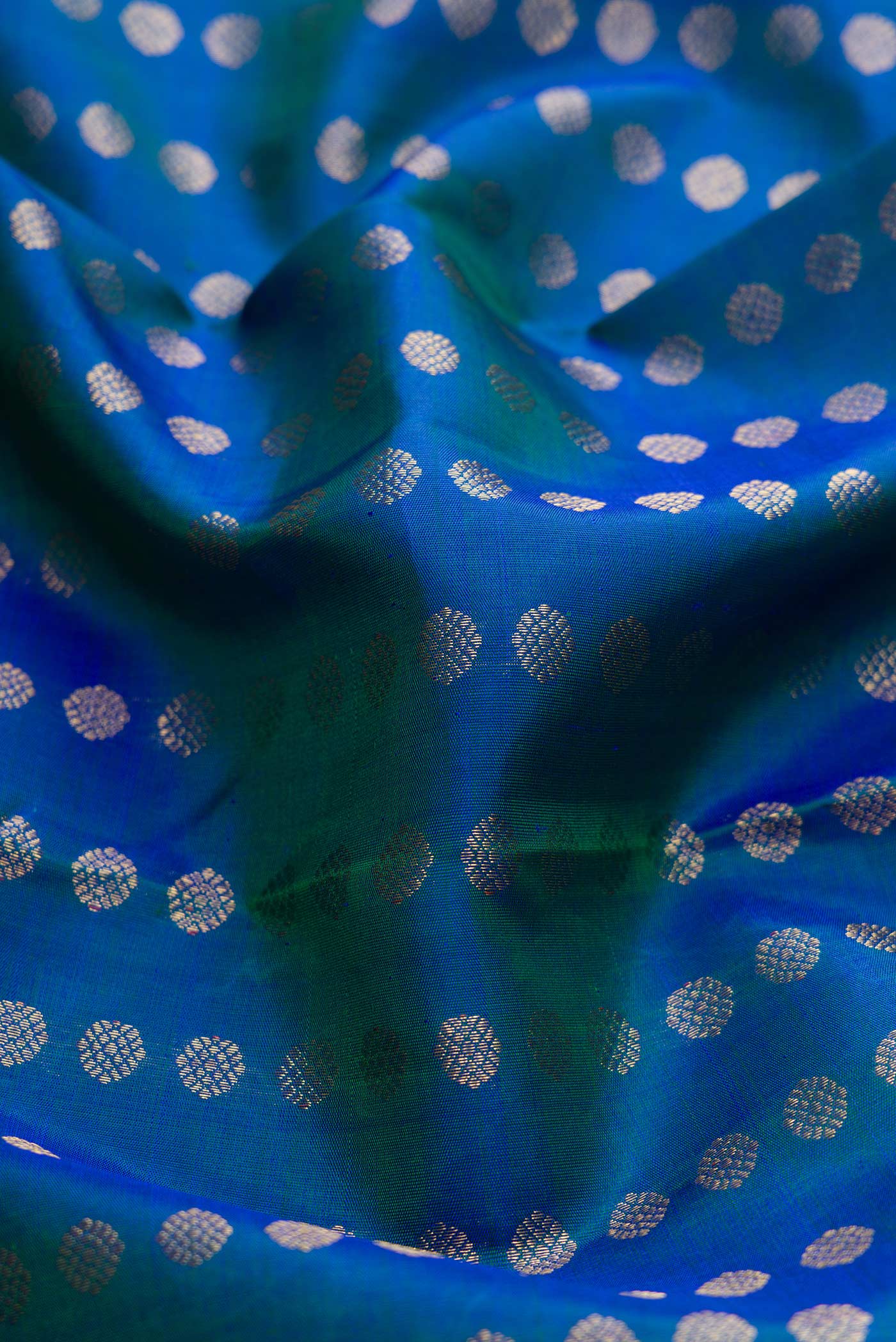 Close up of Pure Silk Pure Zari Peacock Blue Dual Tone Kanchipuram Saree with Zari Butta on the body and Zari Border displaying folds