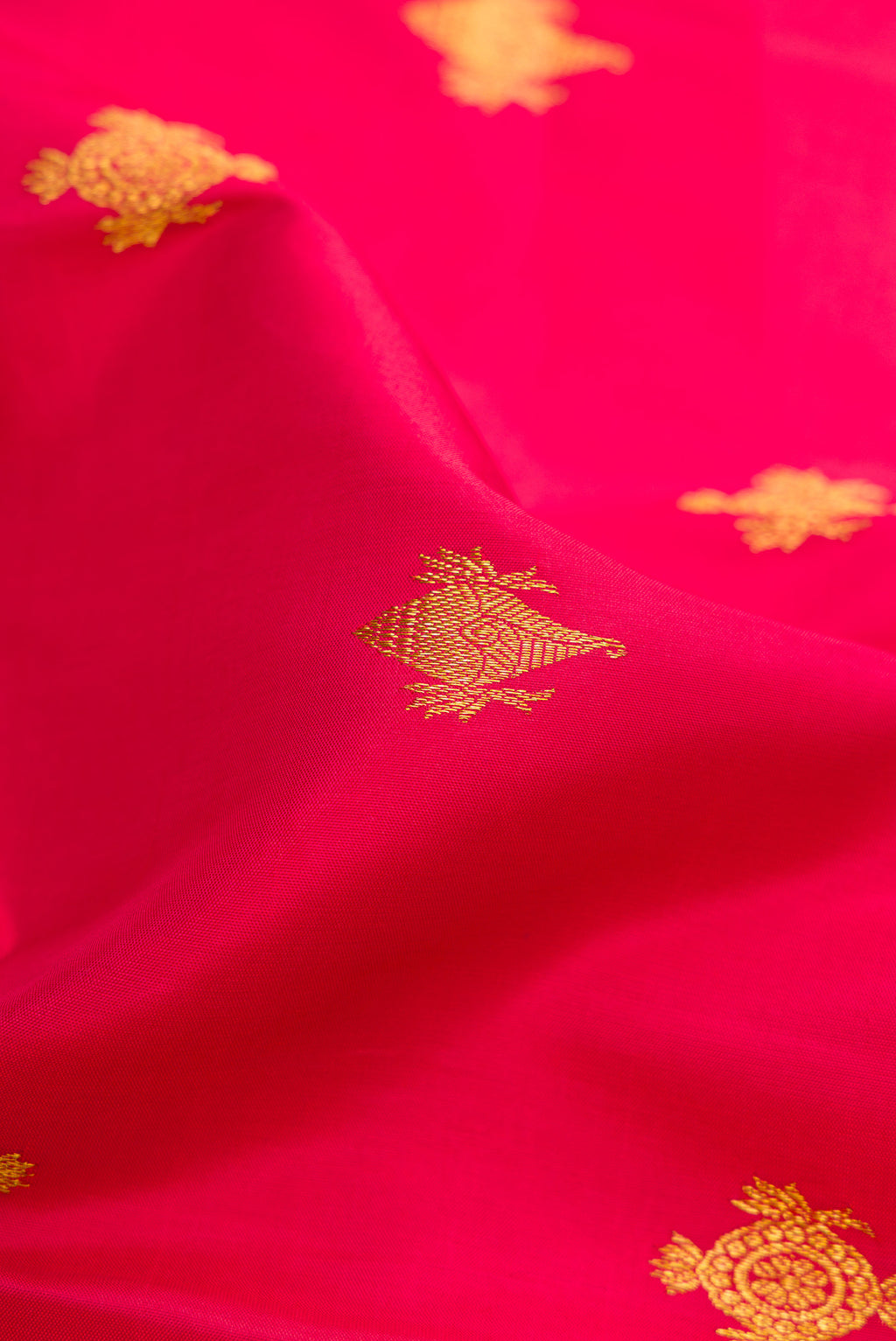 Close up of Deep Red Kanchipuram Silk Saree with Zari Butta on the body and Zari Border.  displaying folds