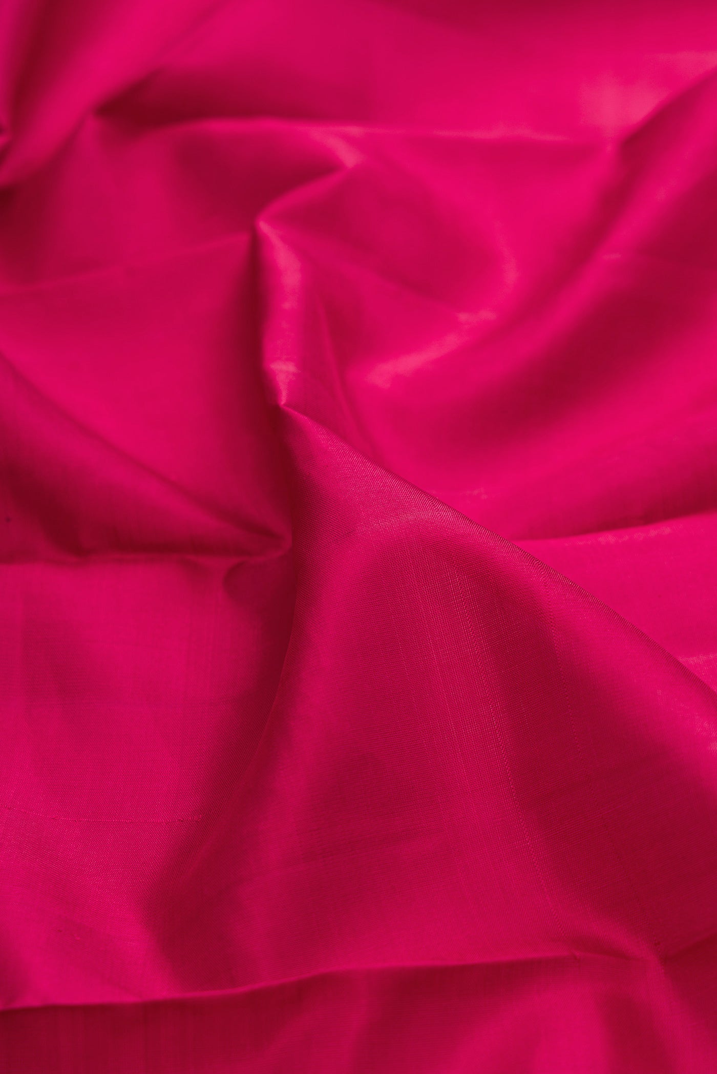 Close up of Maroon Kanjivaram Silk Saree with Plain Body and Zari Border.  displaying folds