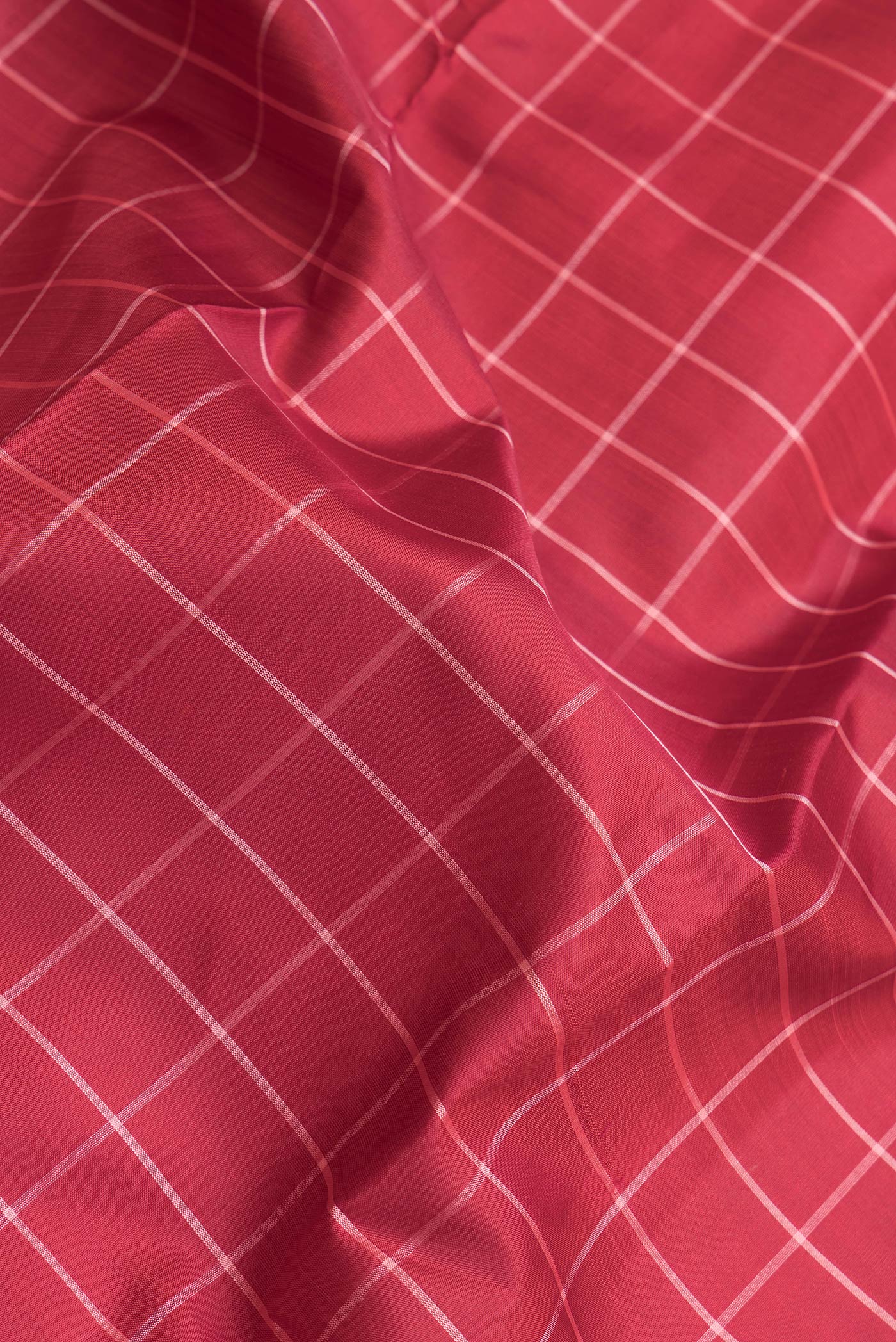 Close up of Maroon Dual Tone Kanjivaram Silk Saree with Checked design on the body and Without Border.  displaying folds