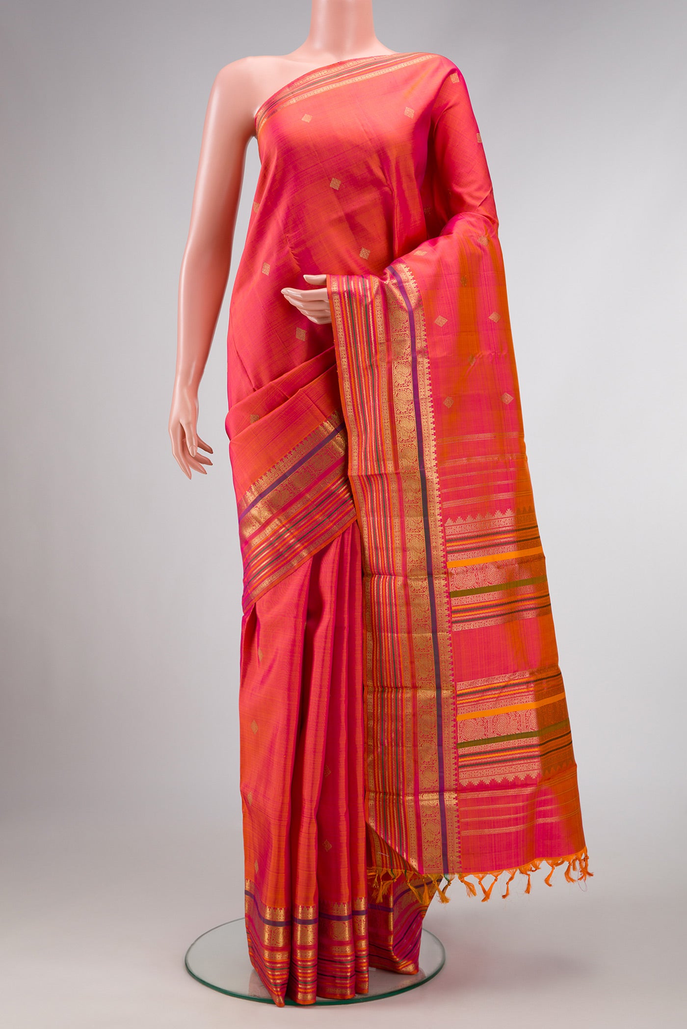 Pure Silk Pure Zari Rose Gold Dual Tone Kanchipuram Saree with Zari Butta on the body and Zari And Thread Border.  displayed on a mannequin
