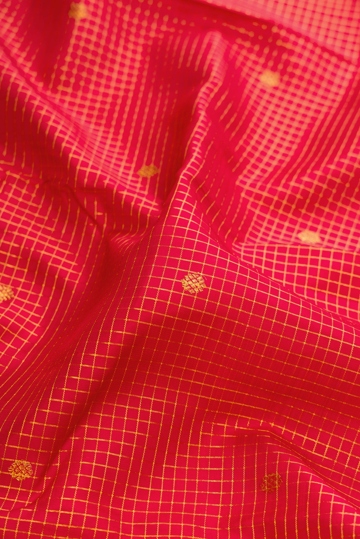 Close up of Deep Red Dual Tone Kanjivaram Silk Saree with Checked design on the body and Zari Border.  displaying folds