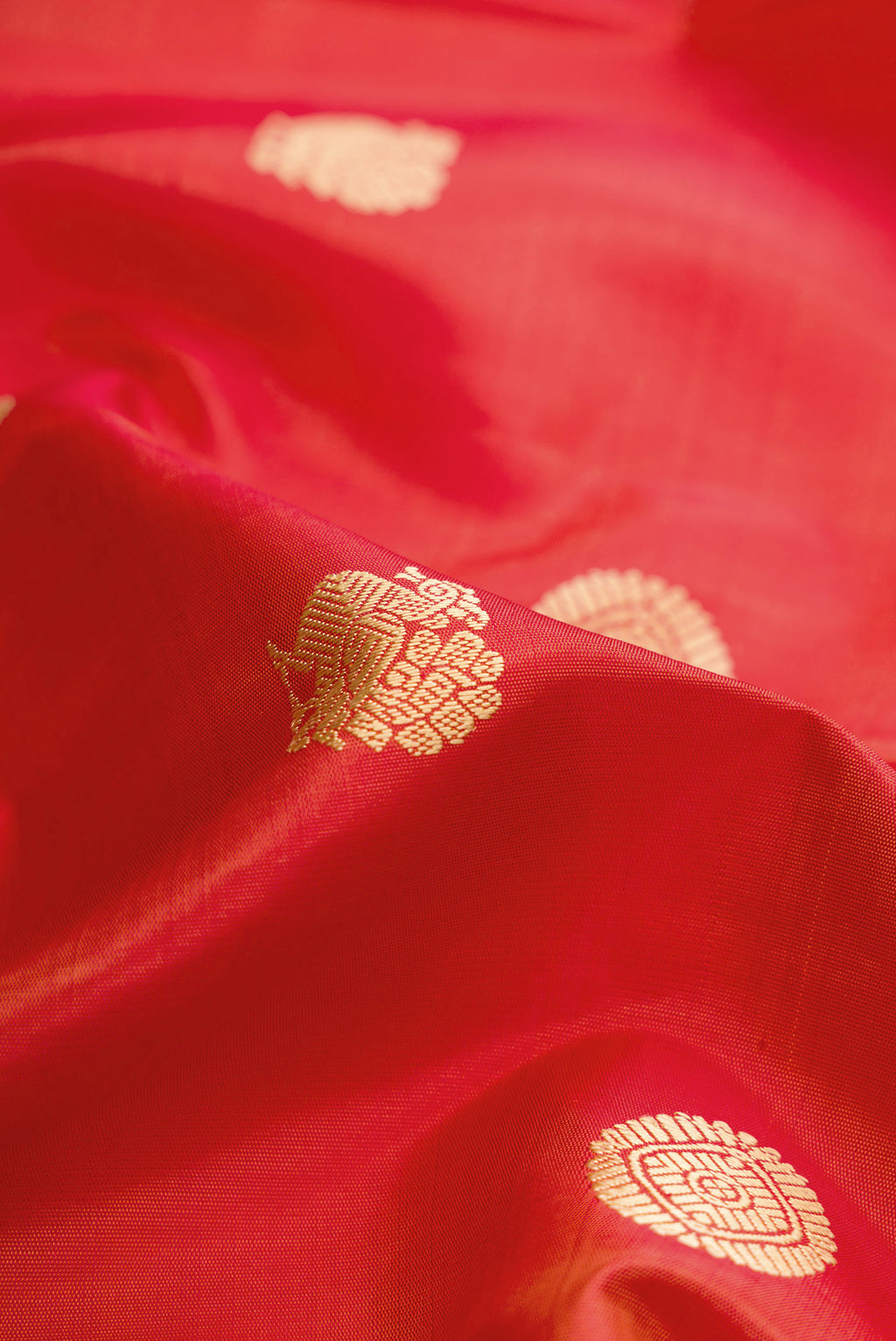 Close up of Orange Dual Tone Kanchipuram Silk Saree with Thread Butta on the body and Thread Border.  displaying folds