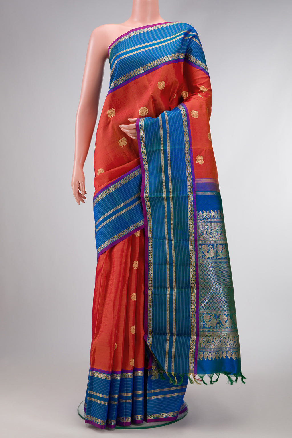 Orange Dual Tone Kanchipuram Silk Saree with Thread Butta on the body and Thread Border.  displayed on a mannequin