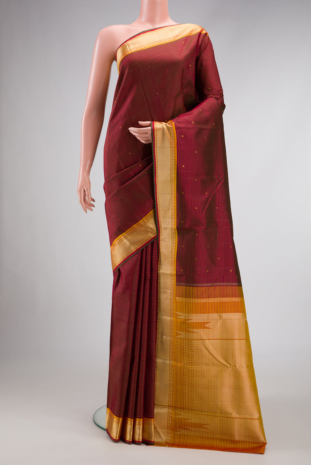 Pure Silk Pure Zari Maroon Dual Tone Kanchipuram Saree with Zari And Thread Butta on the body and Thread Border.  displayed on a mannequin
