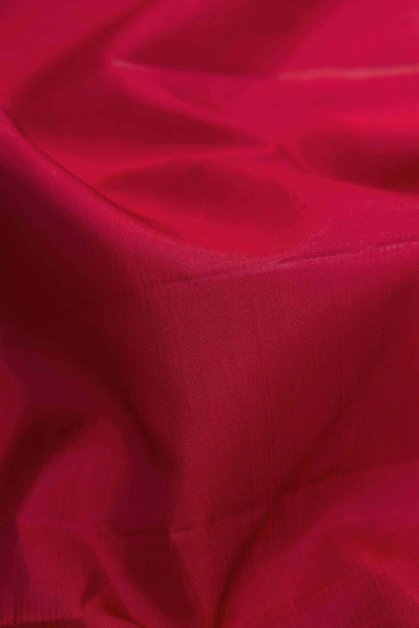Close up of Maroon Dual Tone Kanjivaram Silk Saree with Plain Body and Zari Border.  displaying folds