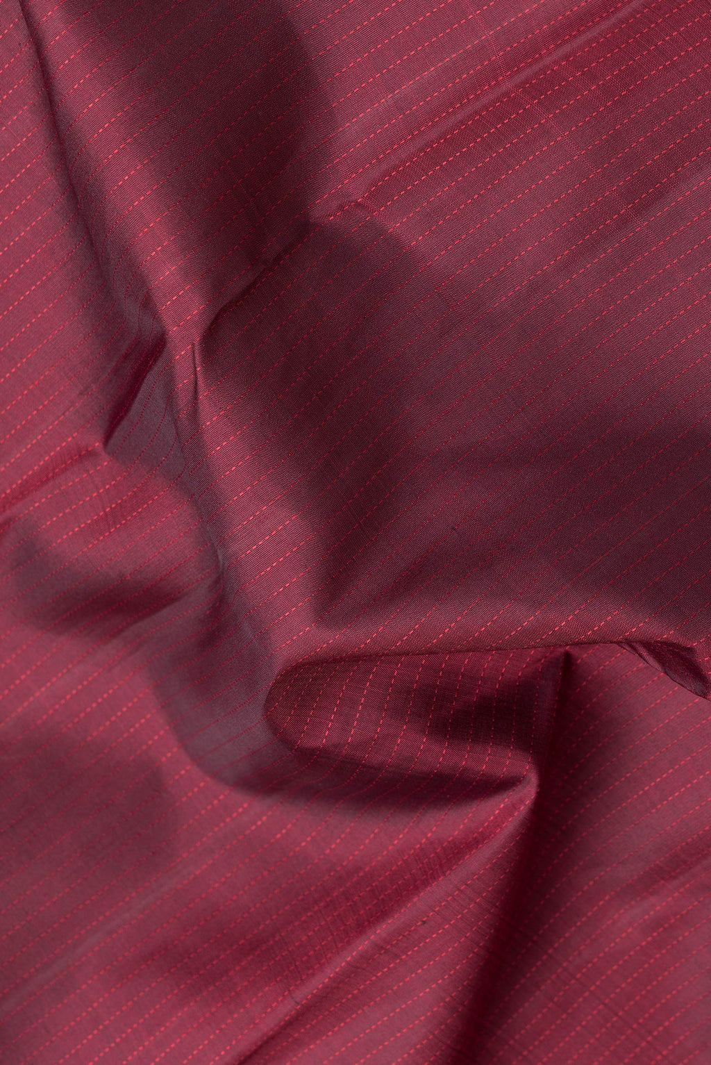 Close up of Maroon Dual Tone Kanjivaram Silk Saree with Stripes on the body and Zari Border.  displaying folds