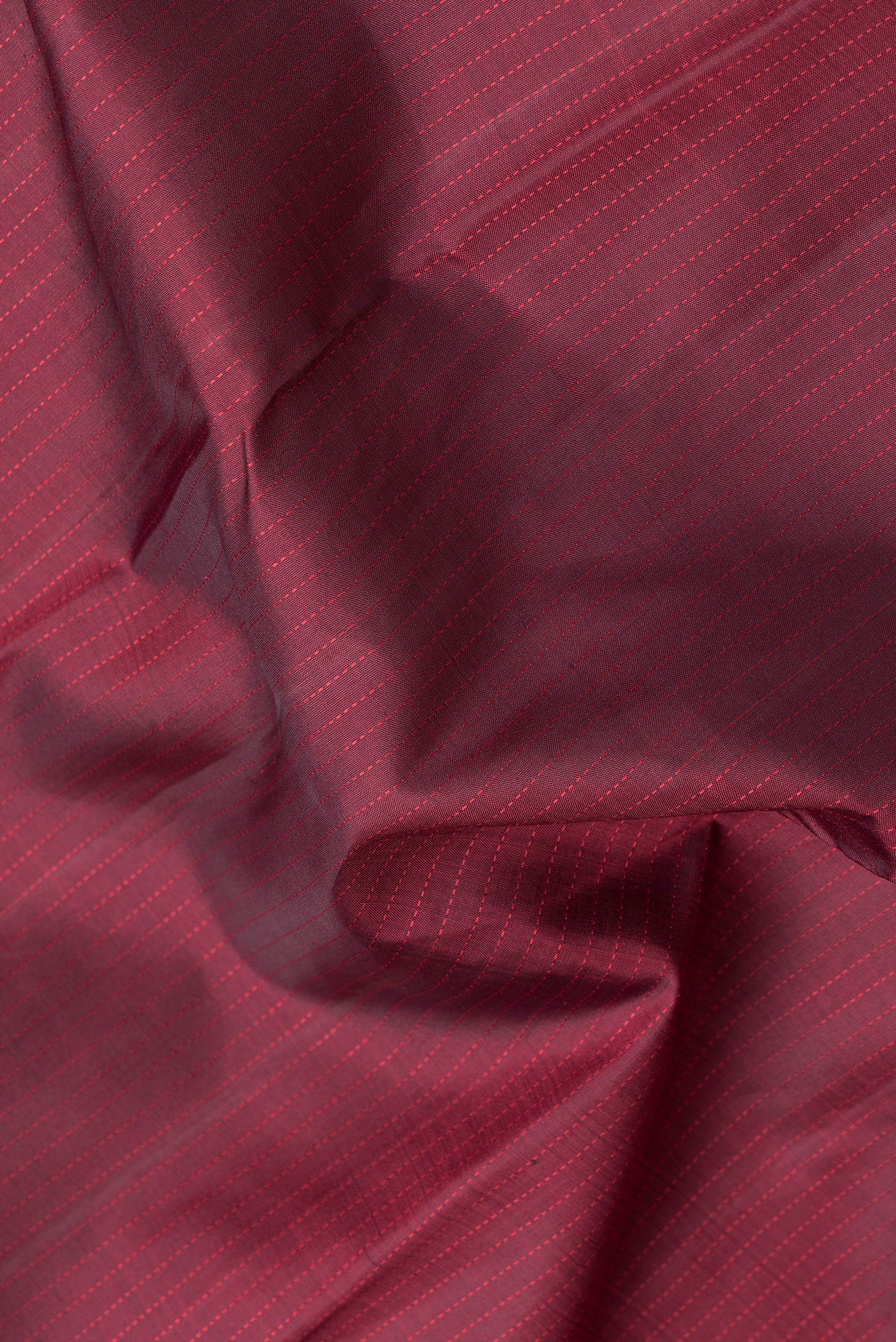 Close up of Maroon Dual Tone Kanjivaram Silk Saree with Stripes on the body and Zari Border.  displaying folds