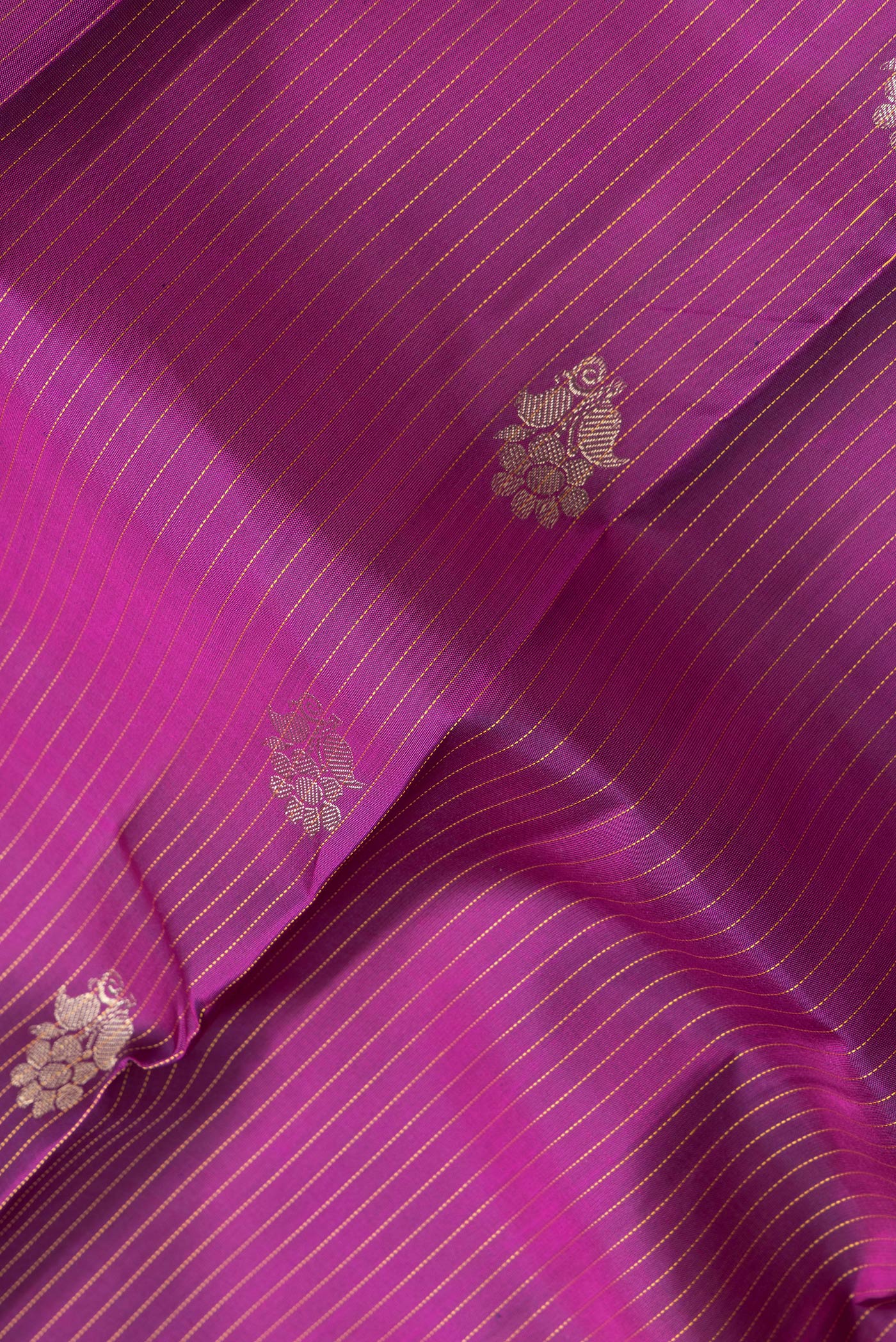 Close up of Magenta Dual Tone Kanjivaram Silk Saree with Stripes on the body and Zari Border.  displaying folds