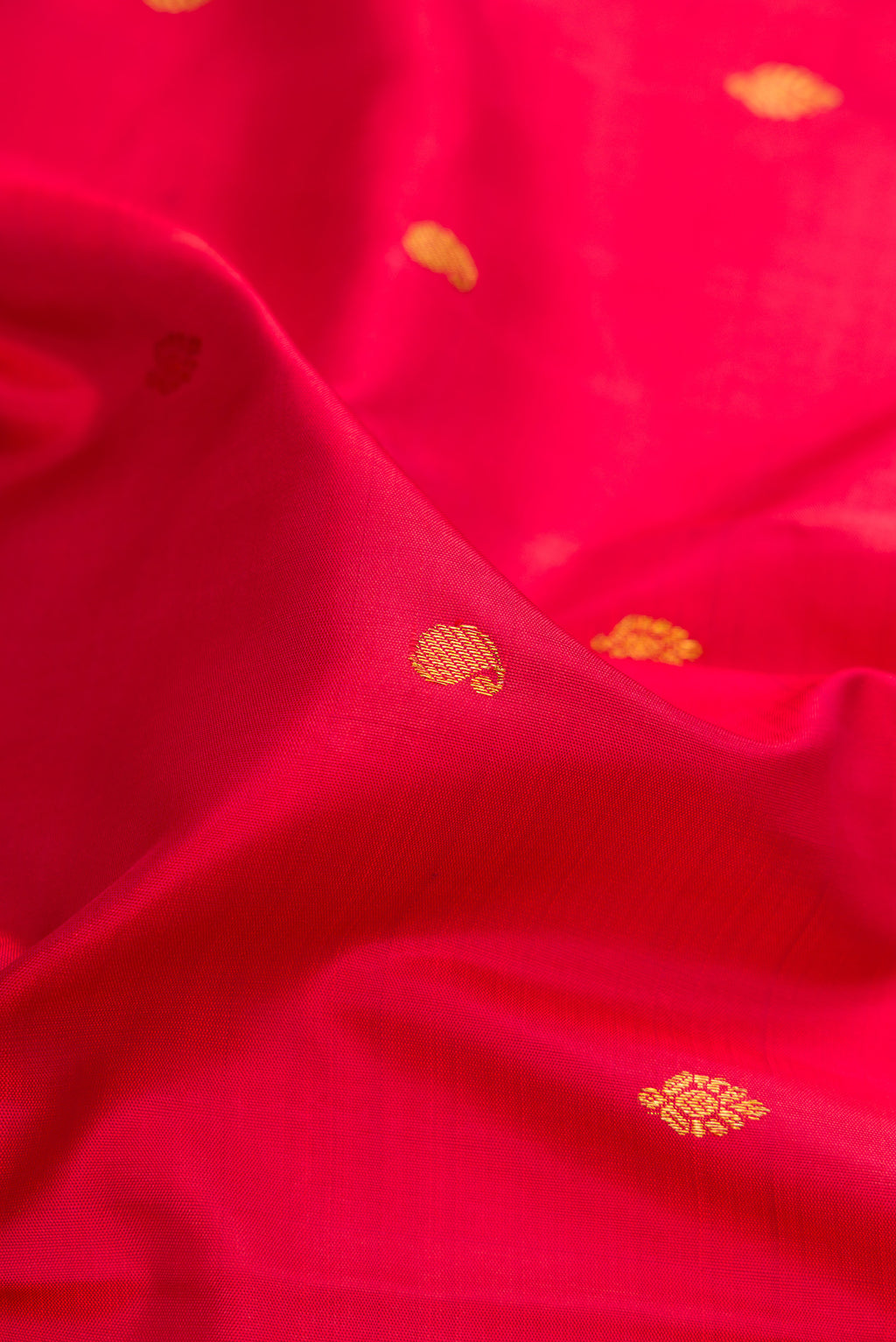 Close up of Red Kanchipuram Silk Saree with Zari Butta on the body and Zari Border.  displaying folds