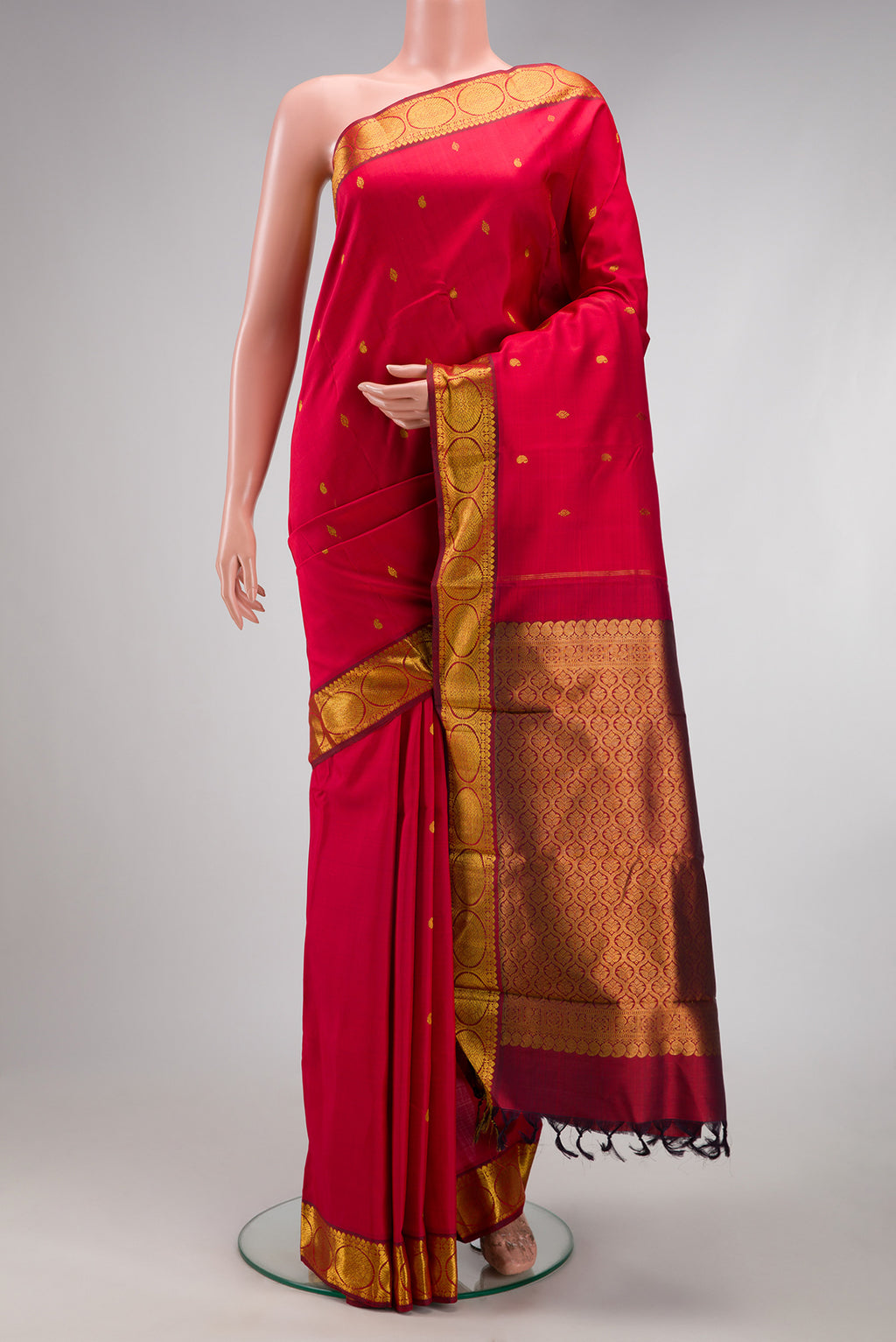 Red Kanchipuram Silk Saree with Zari Butta on the body and Zari Border.  displayed on a mannequin