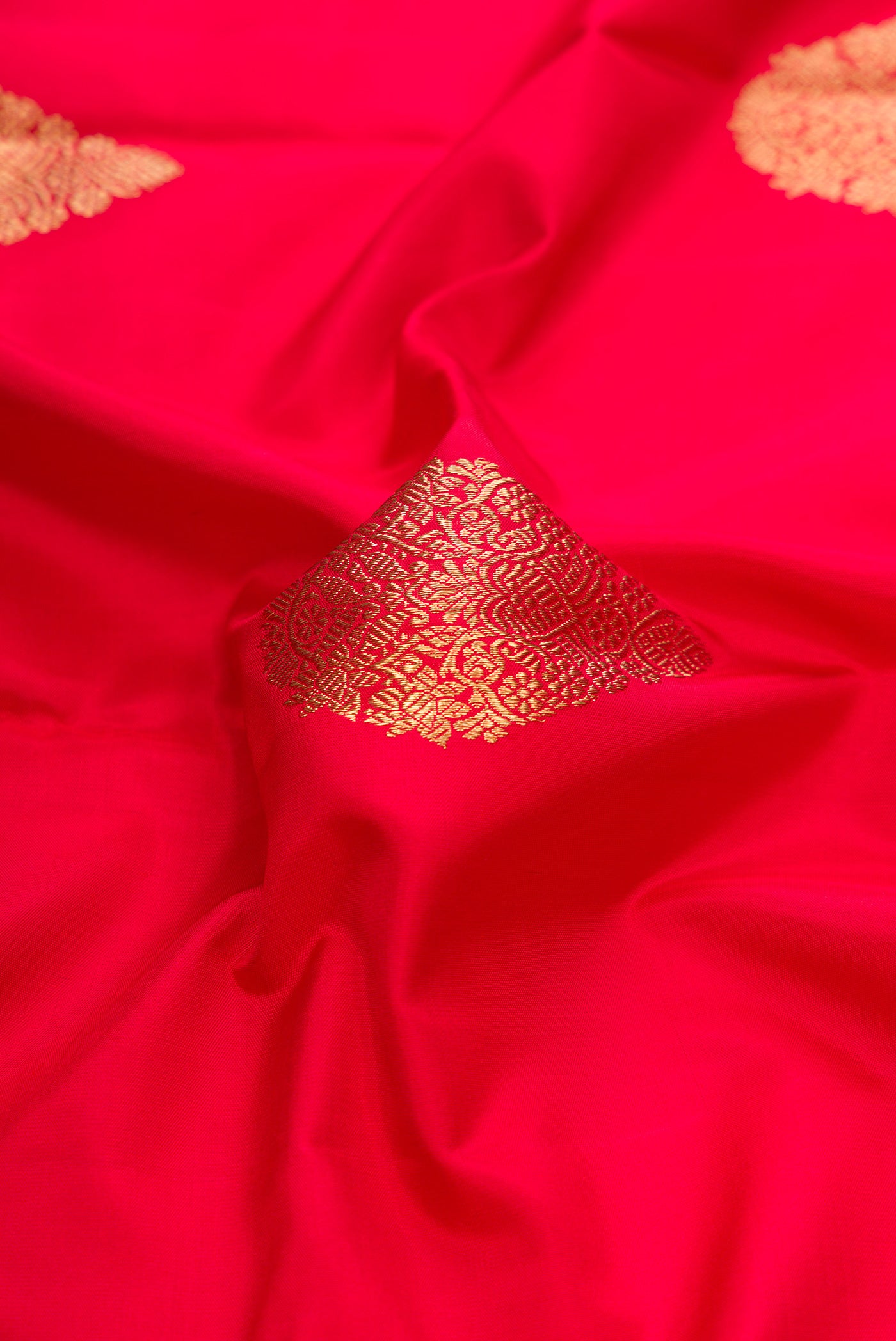 Close up of Pure Silk Pure Zari Red Dual Tone Kanchipuram Saree with Zari Butta on the body and Without Border.  displaying folds