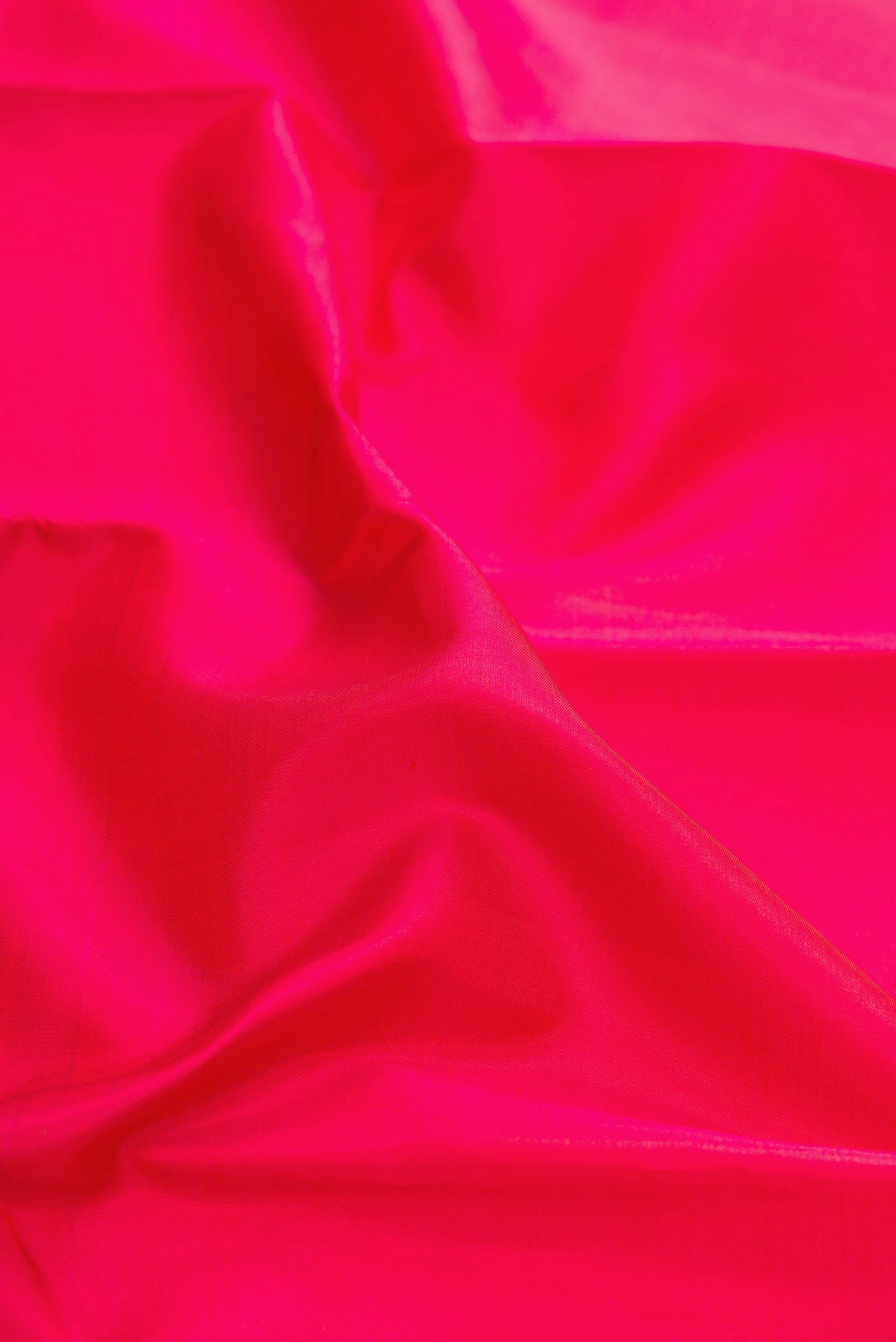 Close up of Dark Pink Dual Tone Kanjivaram Silk Saree with Plain Body and Zari Border.  displaying folds