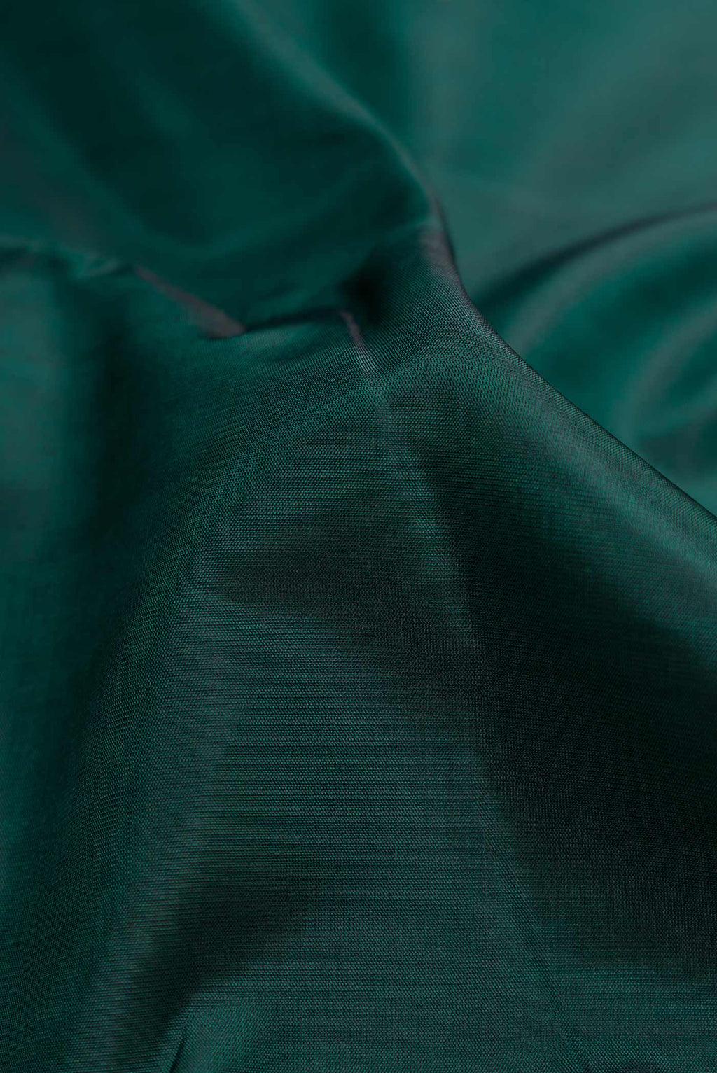 Close up of Bottle Green Dual Tone Kanchipuram Silk Saree with Plain Body and Checks Border.  displaying folds