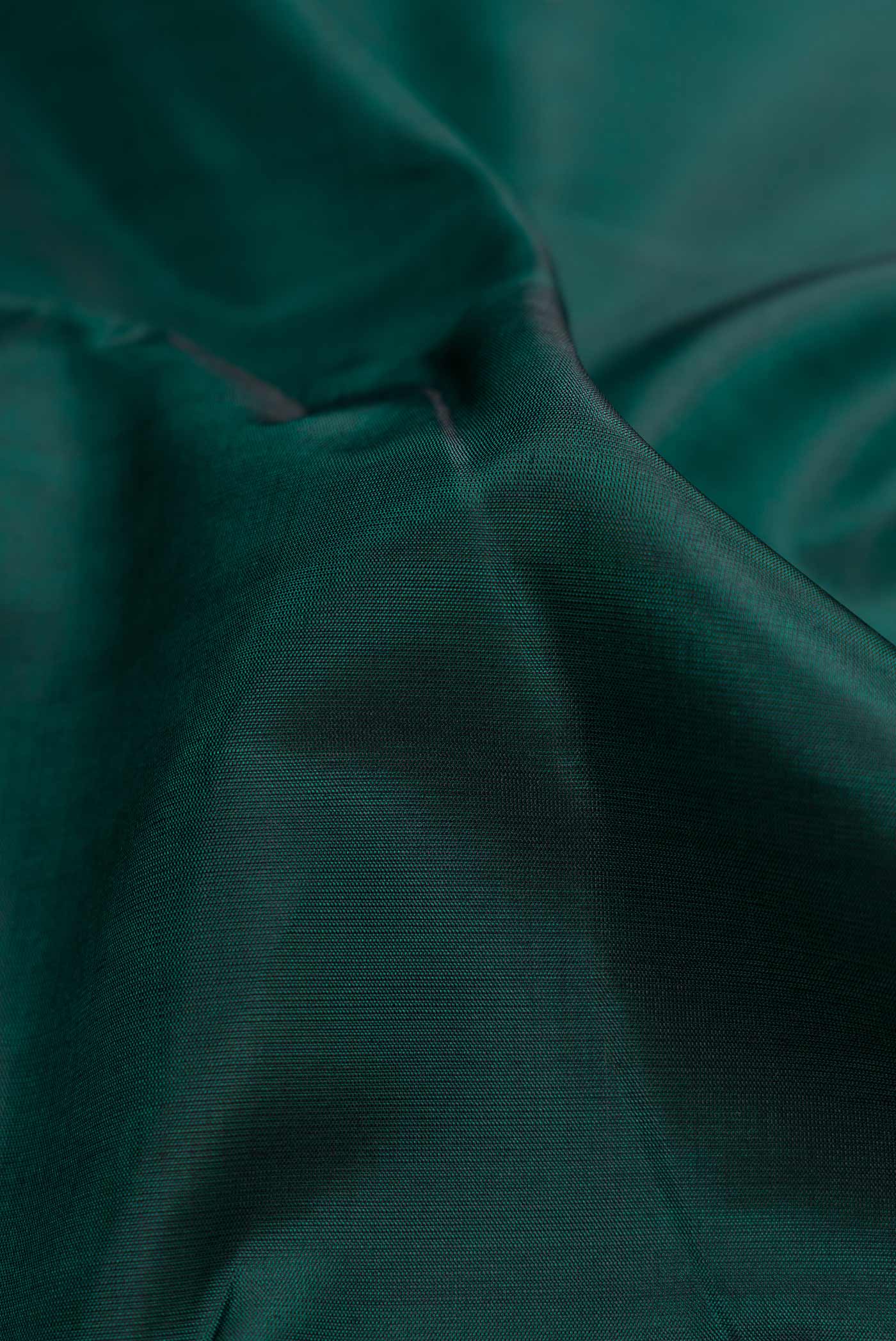 Close up of Bottle Green Dual Tone Kanchipuram Silk Saree with Plain Body and Checks Border.  displaying folds
