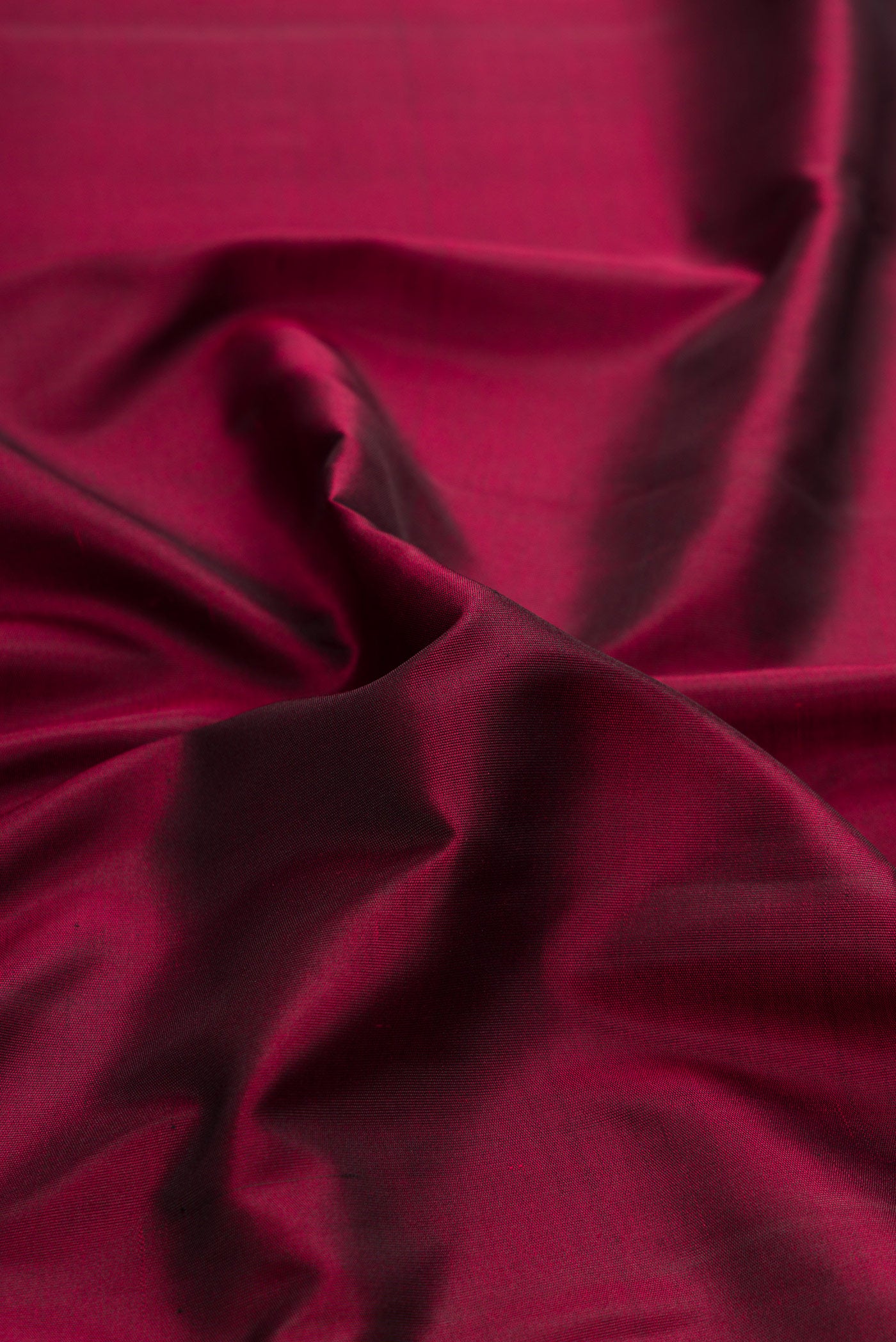 Close up of Pure Silk Pure Zari Maroon Dual Tone Kanchipuram Saree with Plain Body and Rising Temple Border.  displaying folds