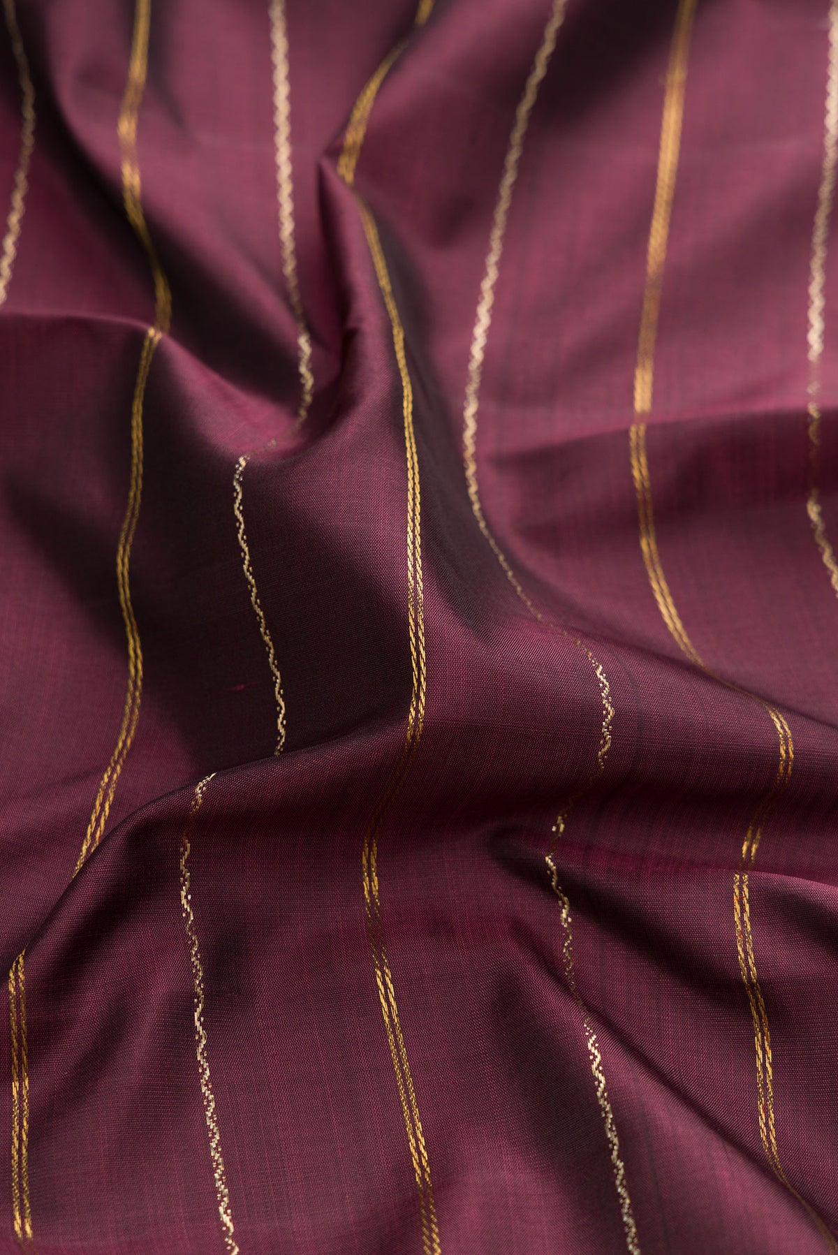 Close up of Coffee Brown Dual Tone Kanchipuram Silk Saree with Stripes on the body and Ganga Jamuna Border.  displaying folds