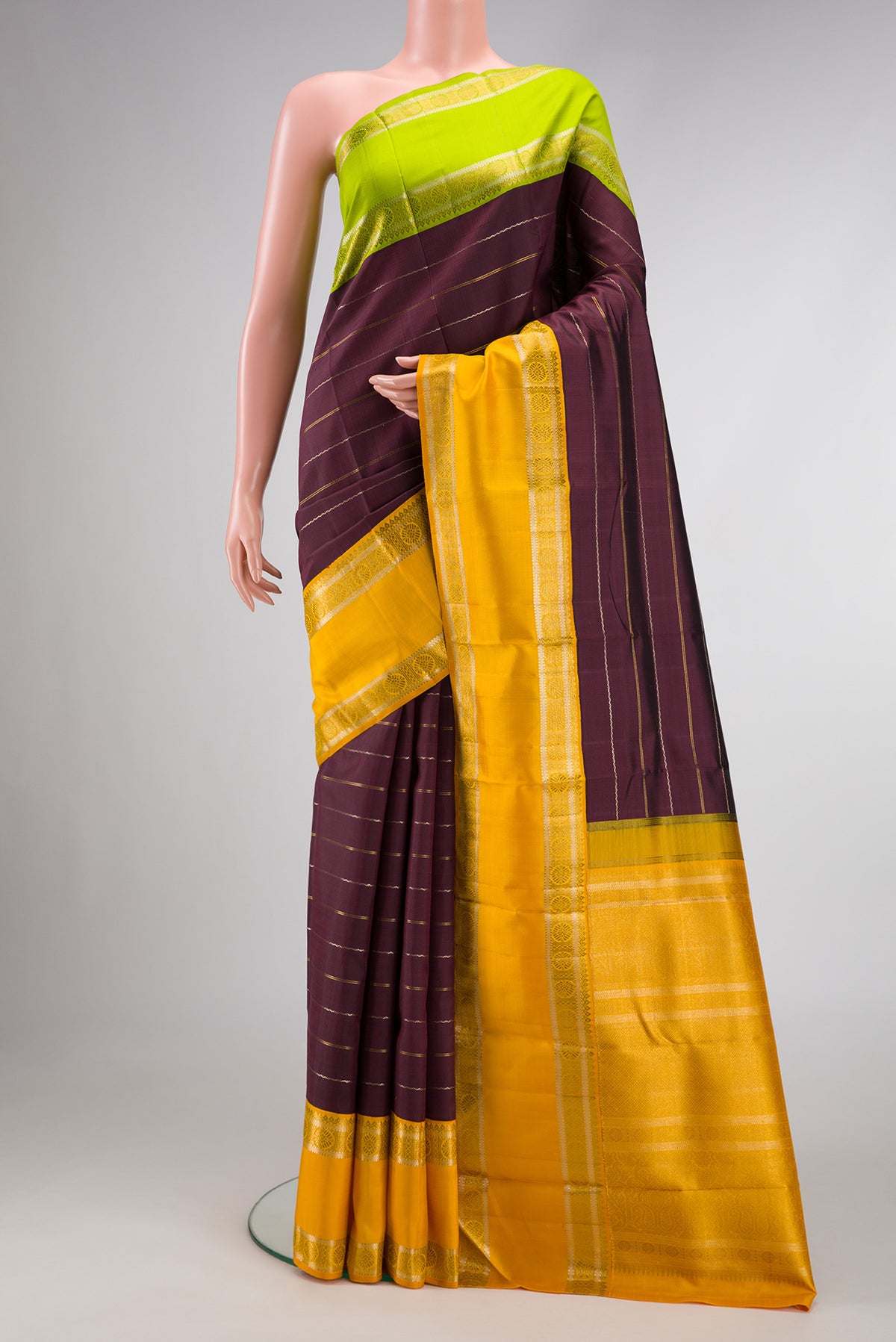 Coffee Brown Dual Tone Kanchipuram Silk Saree with Stripes on the body and Ganga Jamuna Border.  displayed on a mannequin