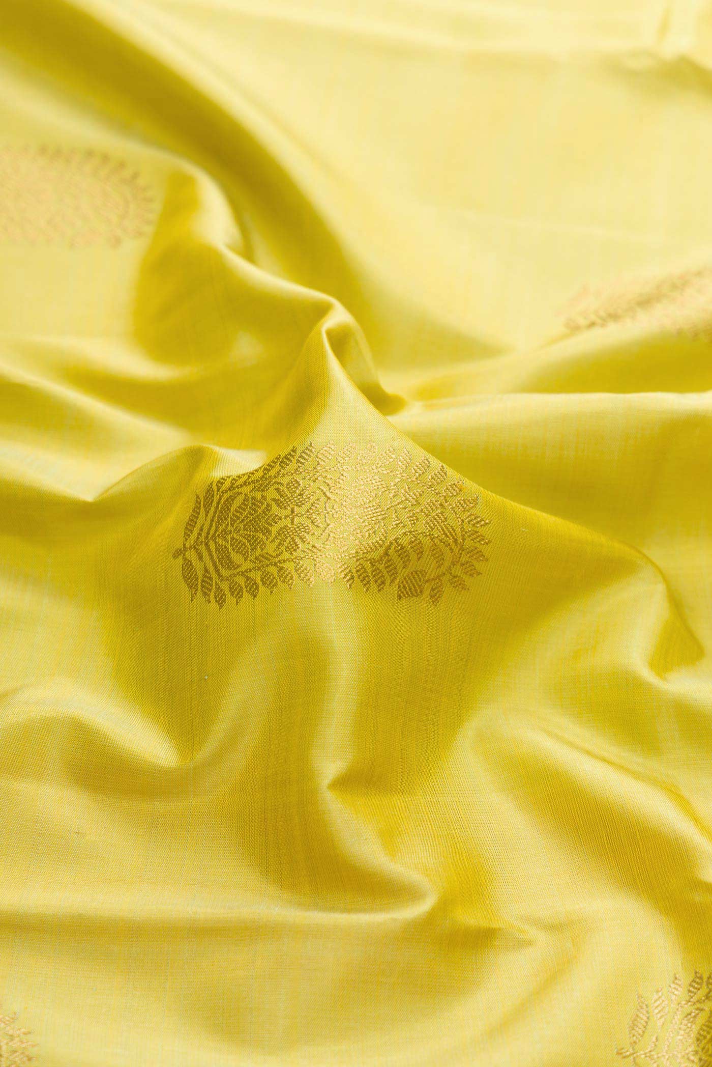 Close up of Pure Silk Pure Zari Lemon Yellow Dual Tone Kanchipuram Saree with Zari Butta on the body and Zari Border displaying folds