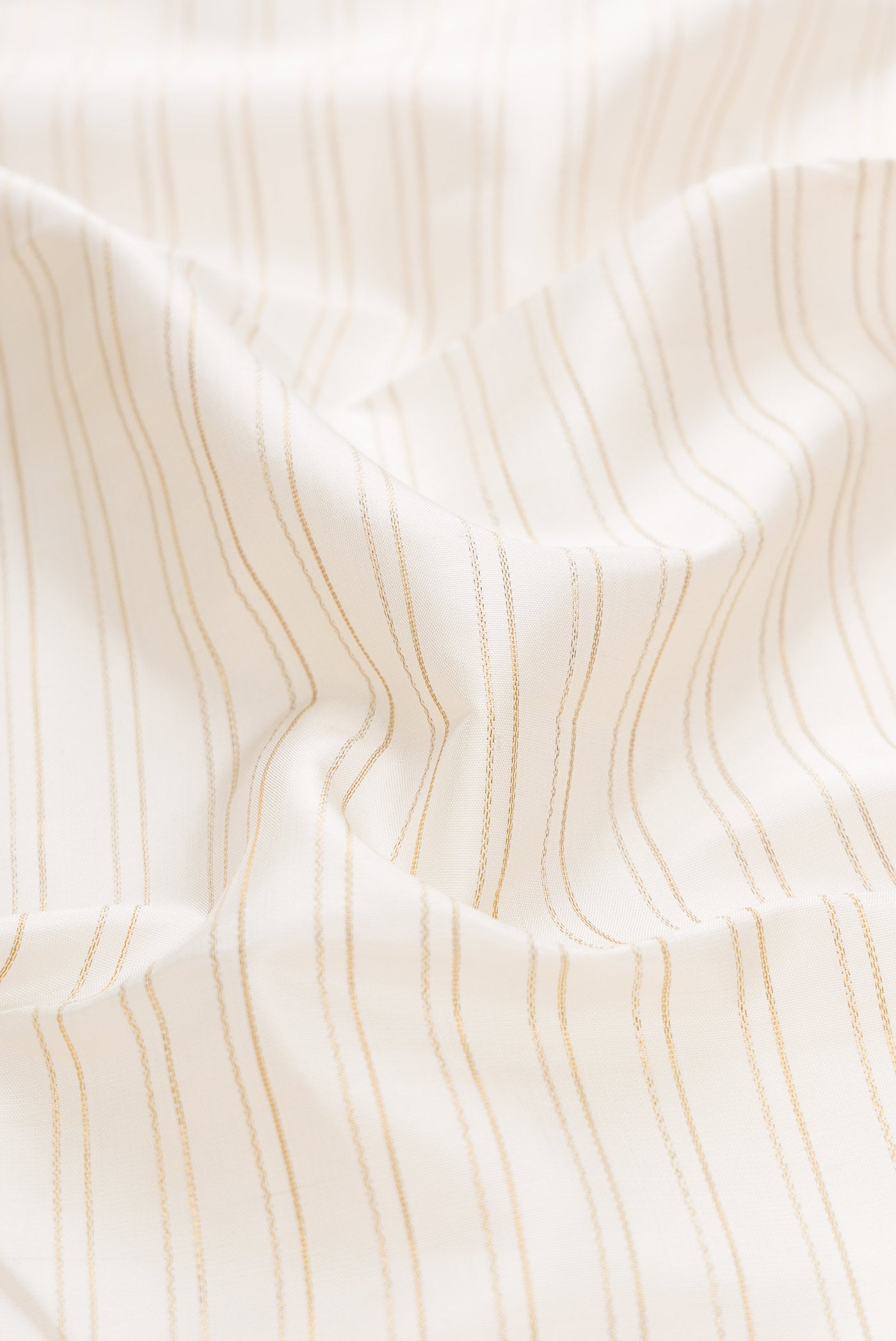 Close up of Pure Silk Pure Zari Off White Dual Tone Kanchipuram Saree with Stripes on the body and Zari Border displaying folds