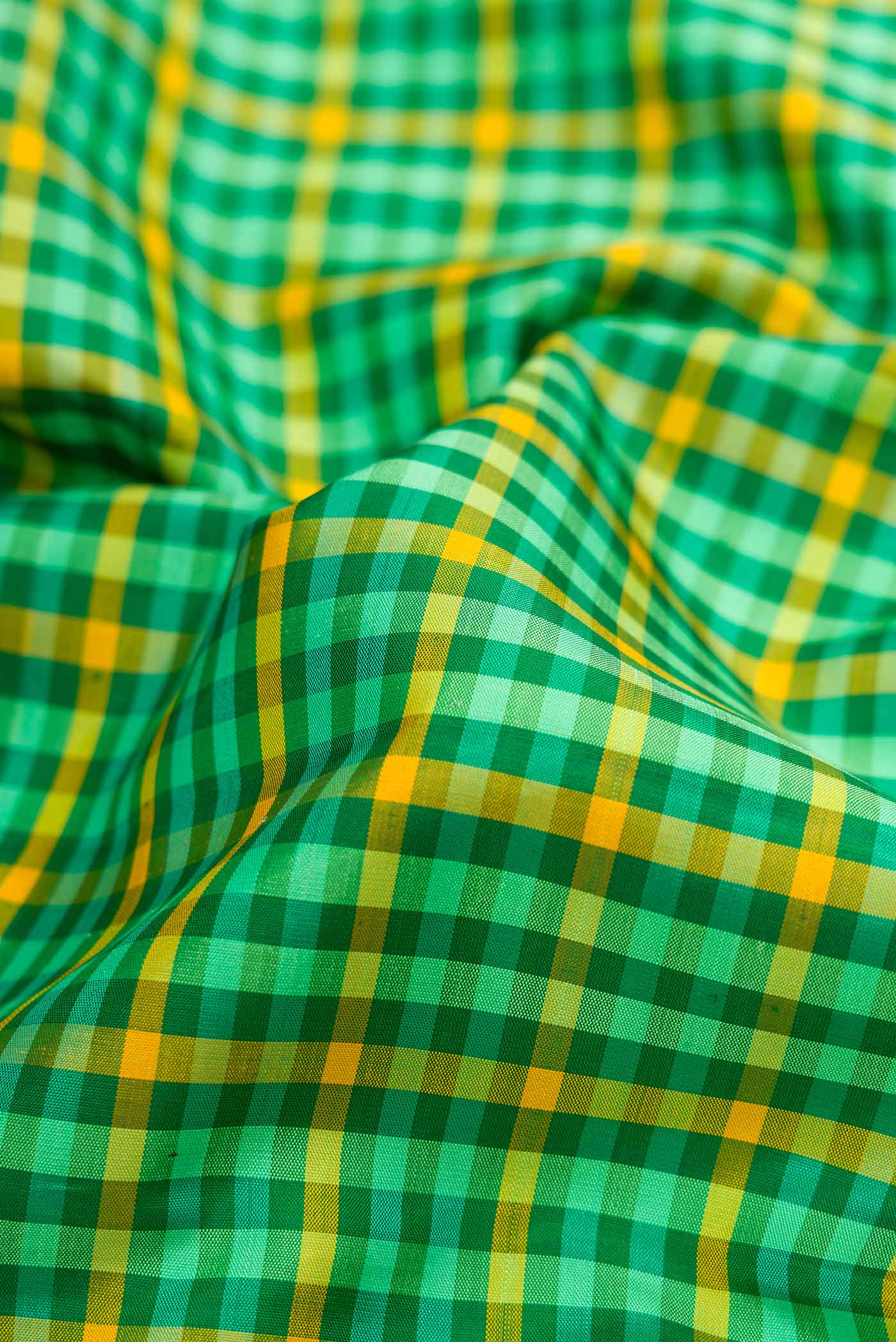 Close up of Pure Silk Pure Zari Green and Yellow Color Kanjivaram Saree with Checked design on the body and Zari Border.  displaying folds