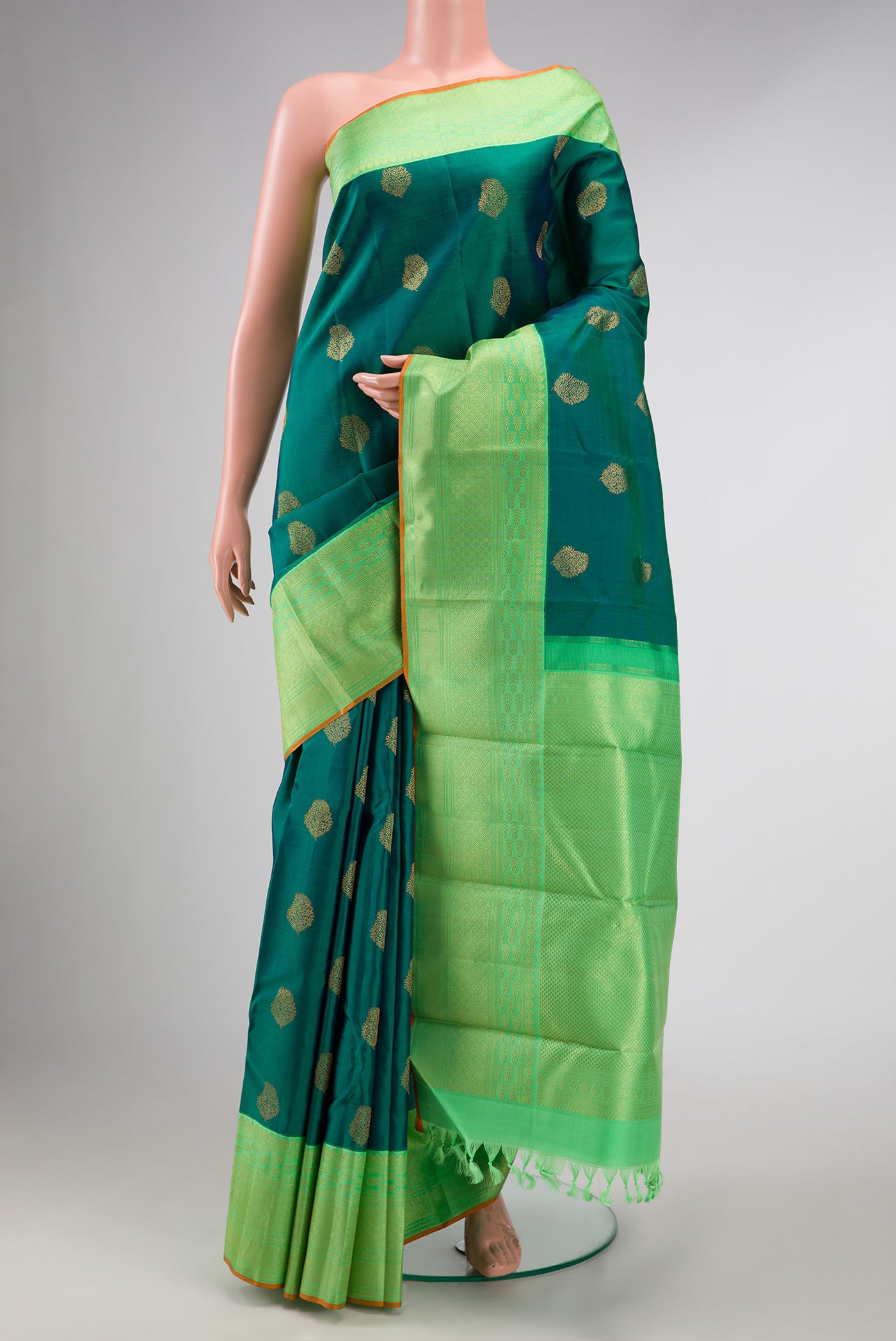 Pure Silk Pure Zari Green Dual Tone Kanchipuram Saree with Zari Butta on the body and Zari Border displayed on a mannequin