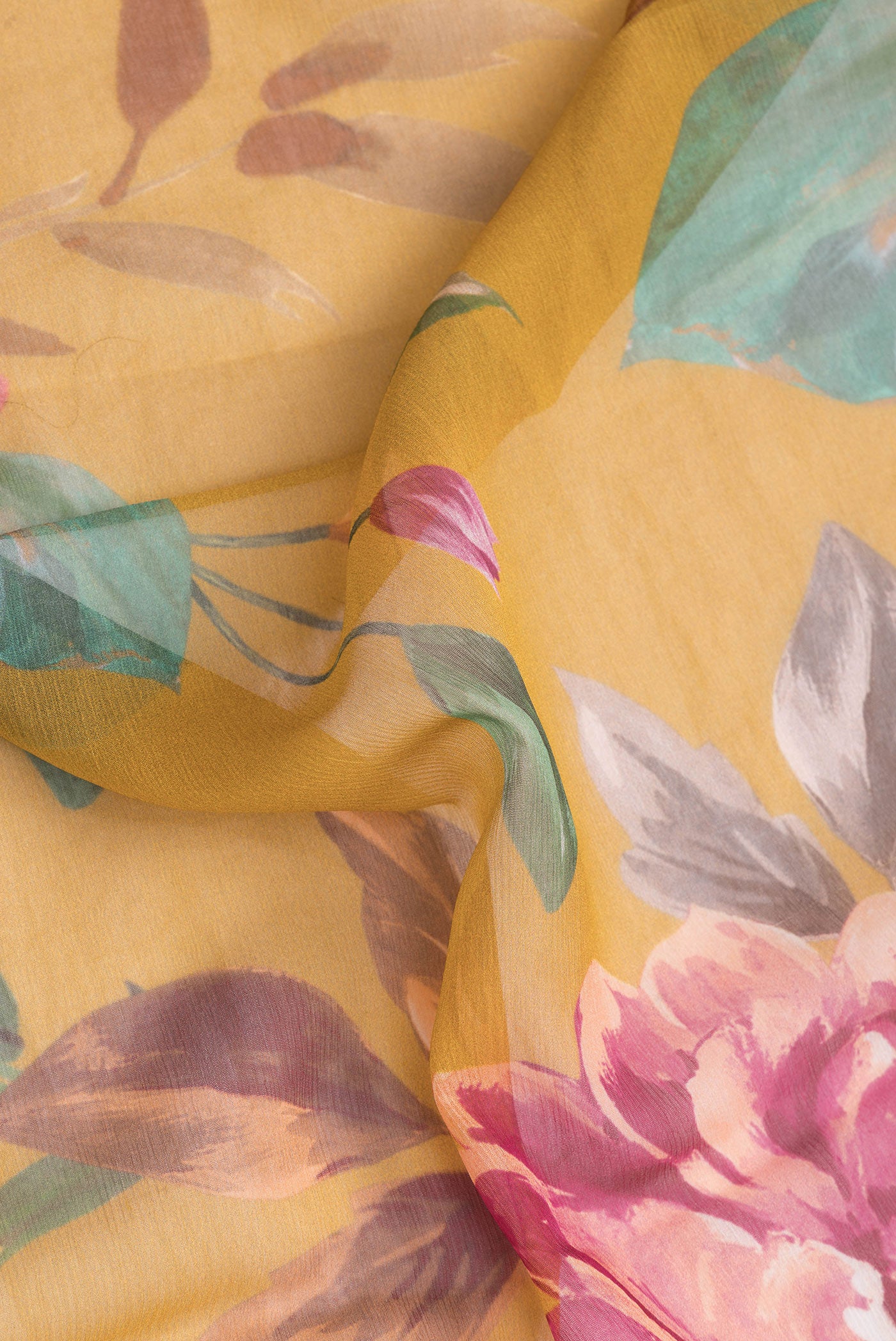 Close up of Mustard Dual Tone Chiffon Saree with Printed design on the body and Without Border.  displaying folds
