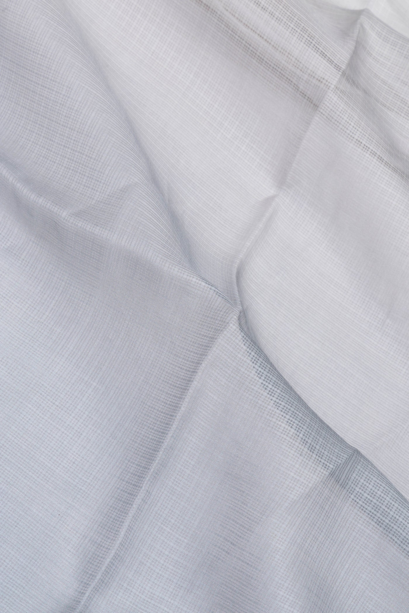 Close up of Grey Kota Silk Saree with Checked design on the body and Thin Zari Line.  displaying folds