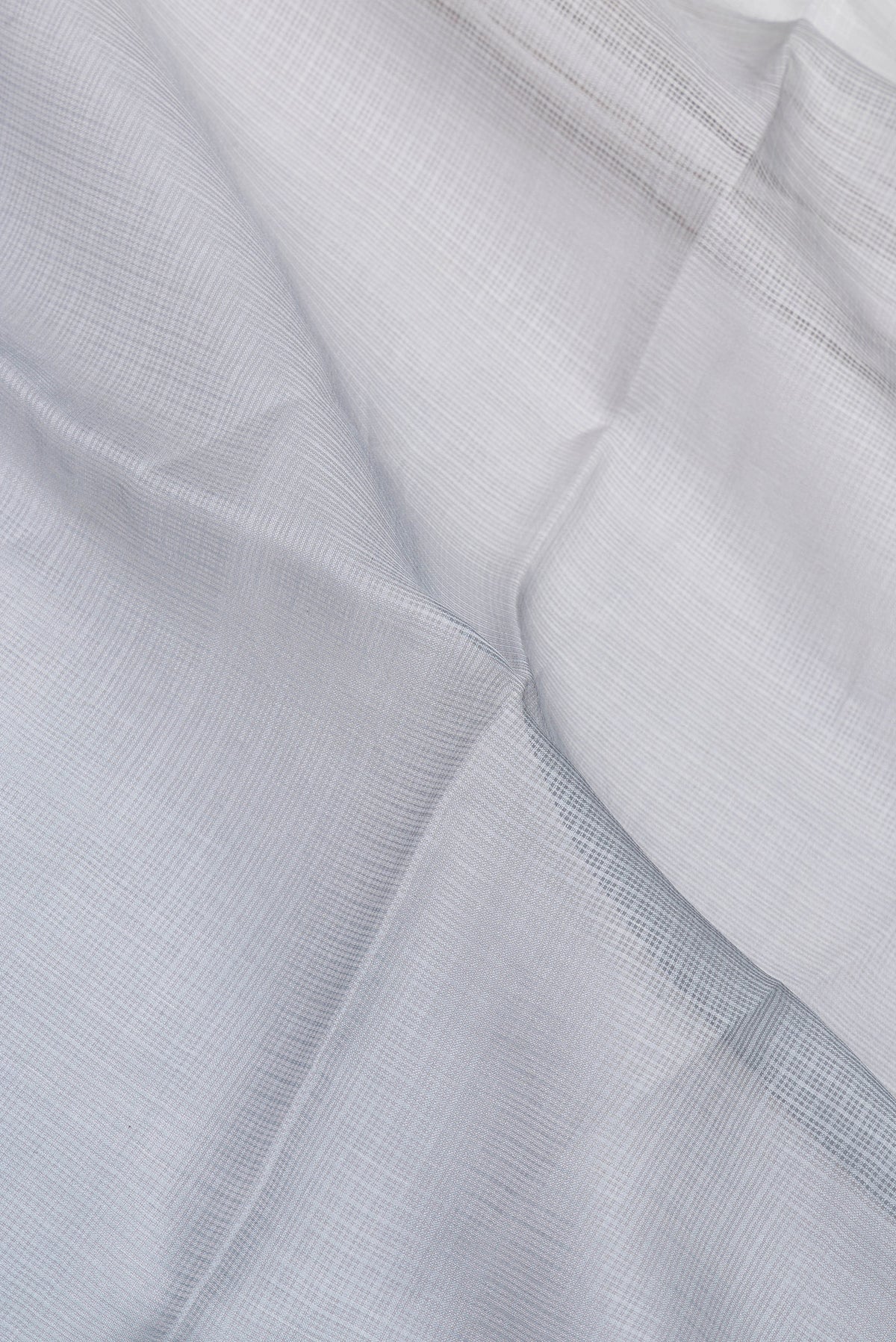 Close up of Grey Kota Silk Saree with Checked design on the body and Thin Zari Line.  displaying folds