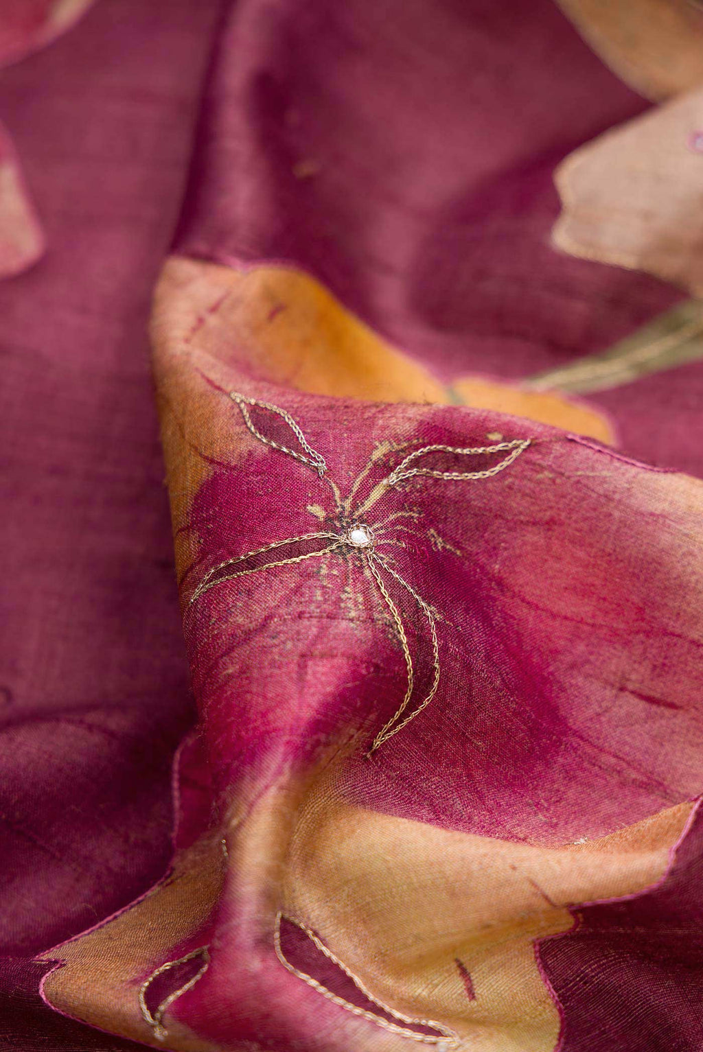 Close up of Magenta Dual Tone Tussar Silk Saree with Embroidery on the body and Embroidery Border displaying folds
