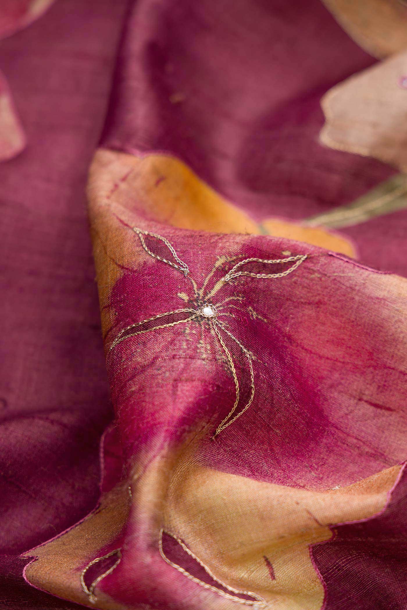 Close up of Magenta Dual Tone Tussar Silk Saree with Embroidery on the body and Embroidery Border displaying folds