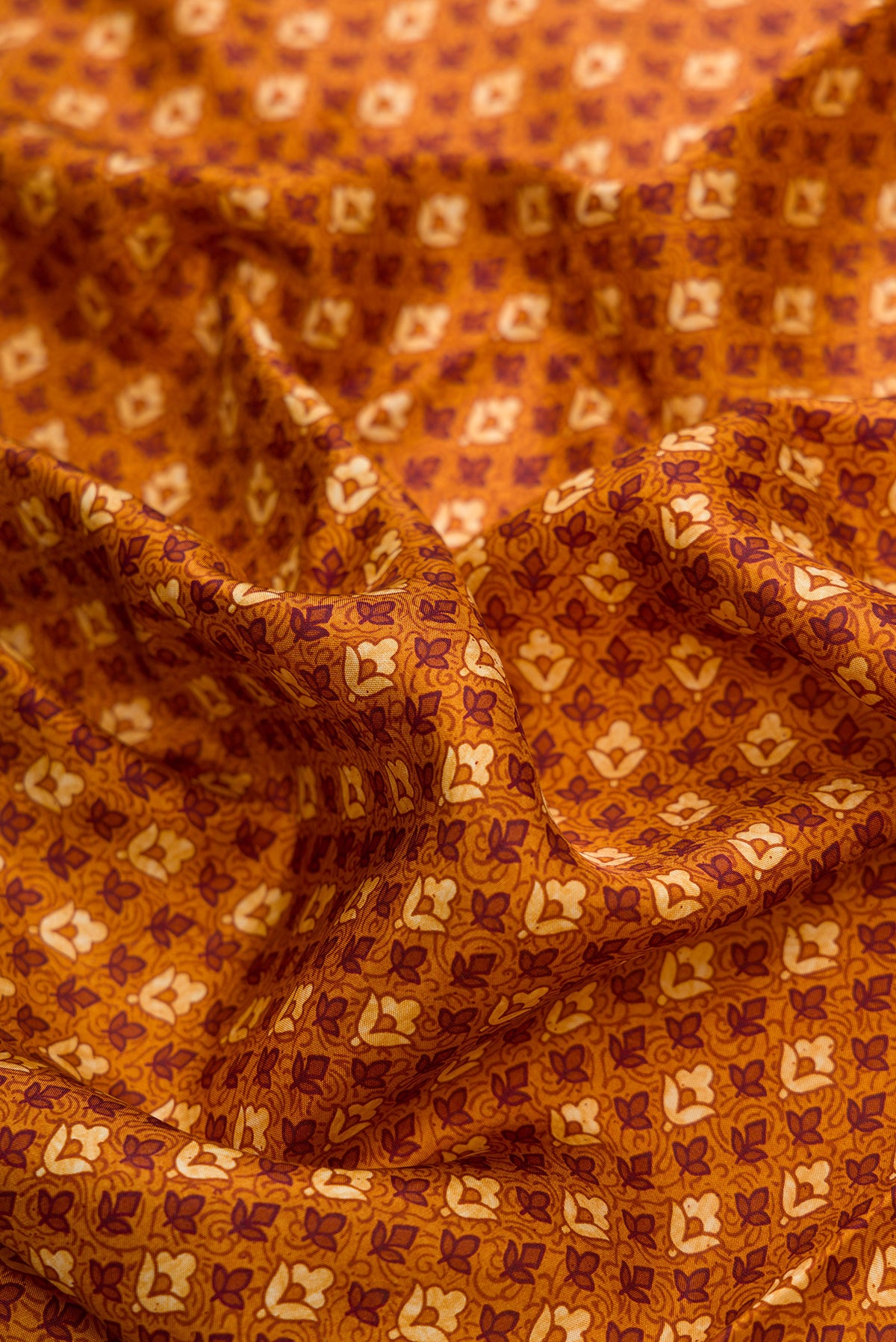 Close up of Mustard Dual Tone Printed Silk Saree with Printed design on the body and Printed Border.  displaying folds