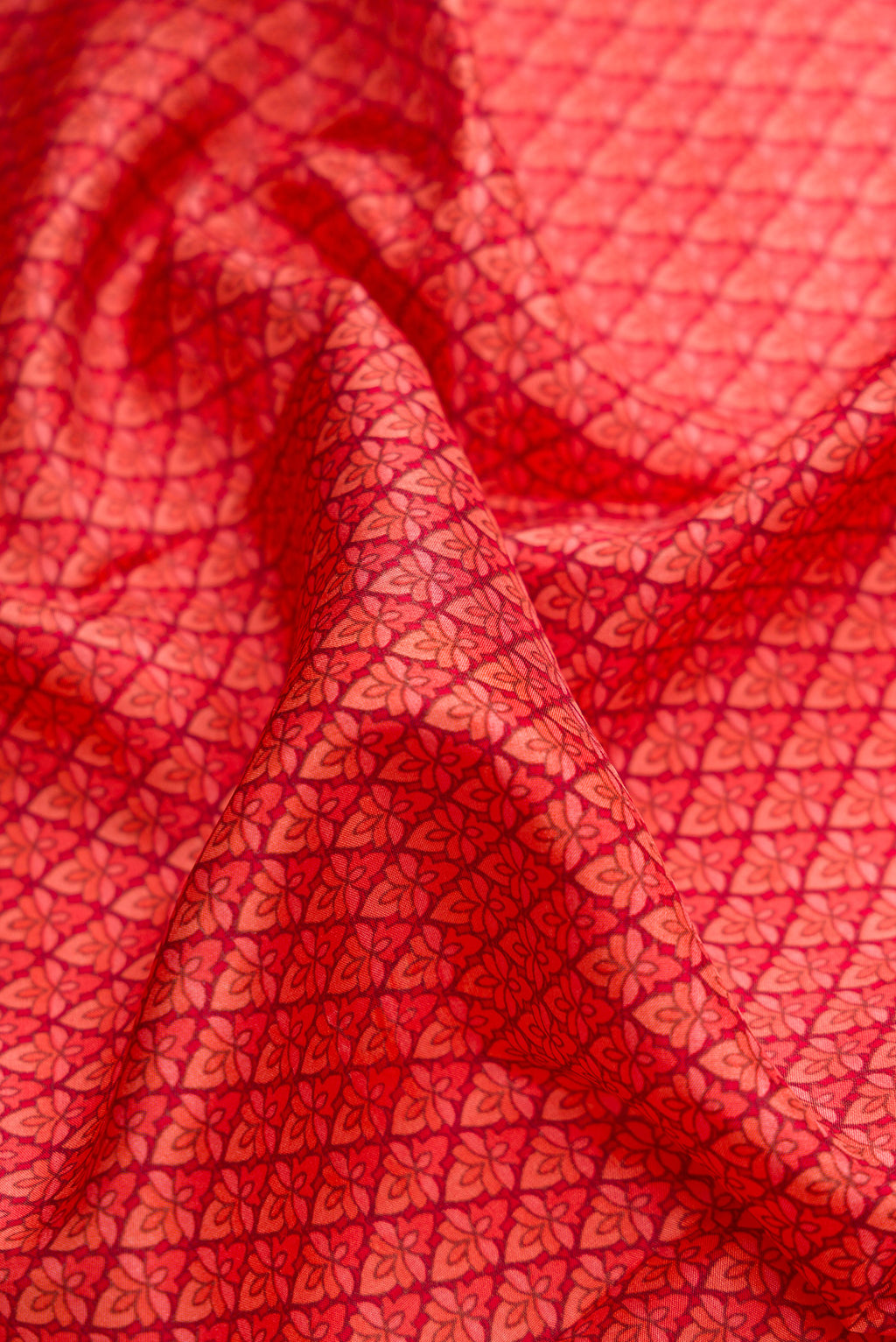 Close up of Red Dual Tone Printed Silk Saree with Printed design on the body and Printed Border.  displaying folds