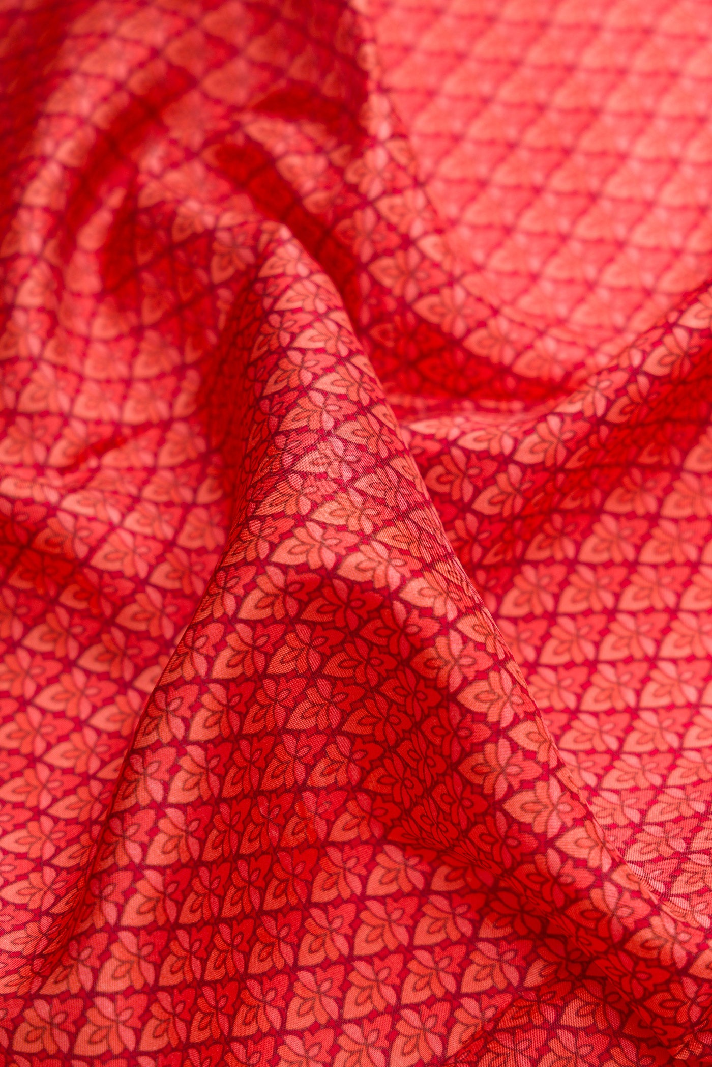 Close up of Red Dual Tone Printed Silk Saree with Printed design on the body and Printed Border.  displaying folds