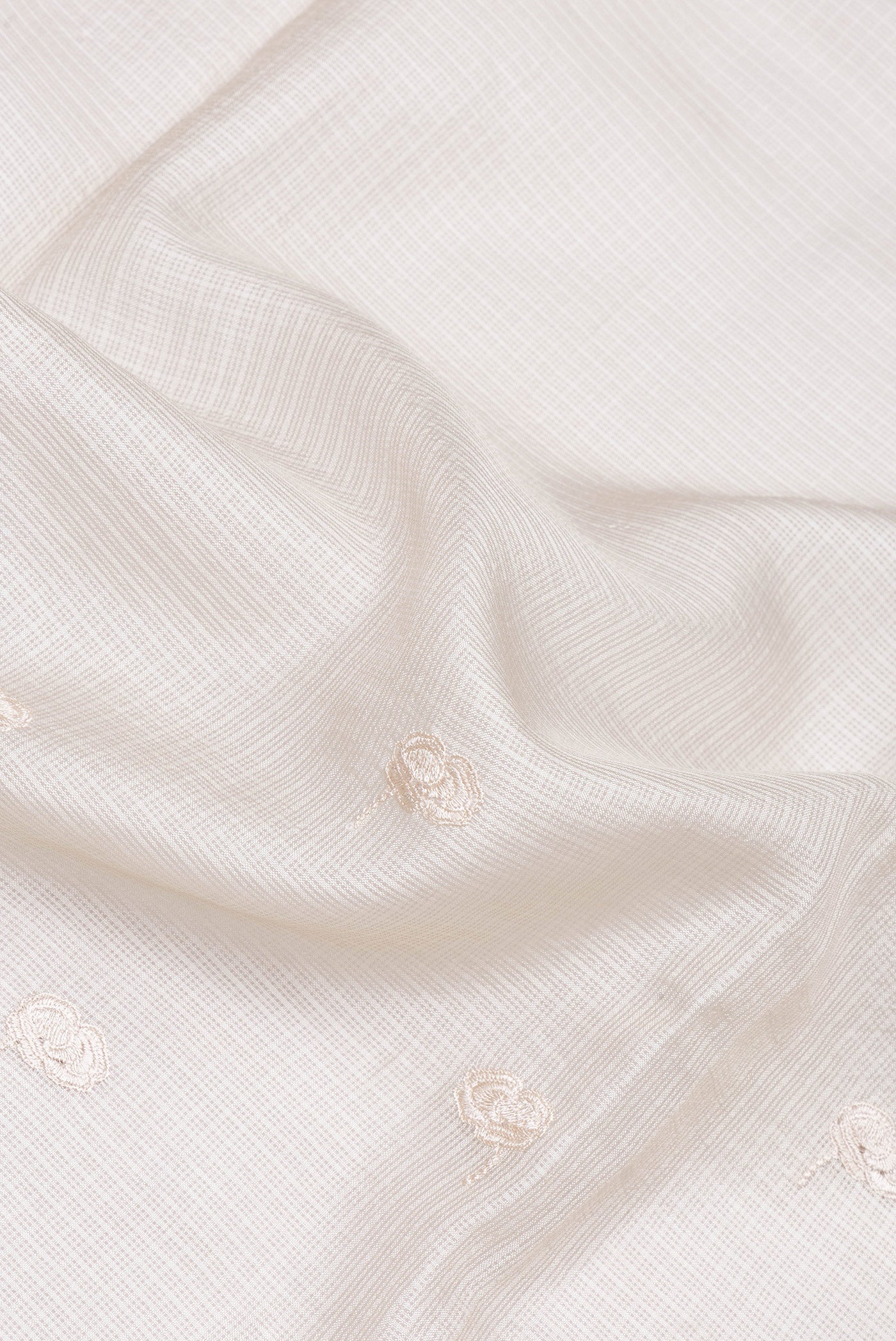 Close up of Beige Kota Silk Saree with Embroidery on the body and Embroidery Border.  displaying folds