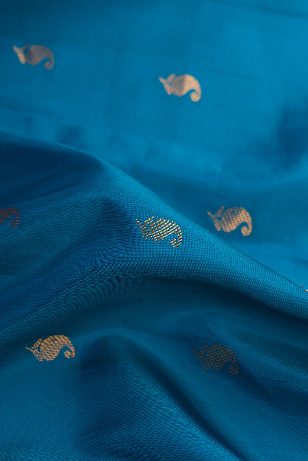 Close up of Peacock Blue Dual Tone Gadwal Silk Saree with Zari Butta on the body and Zari Border.  displaying folds